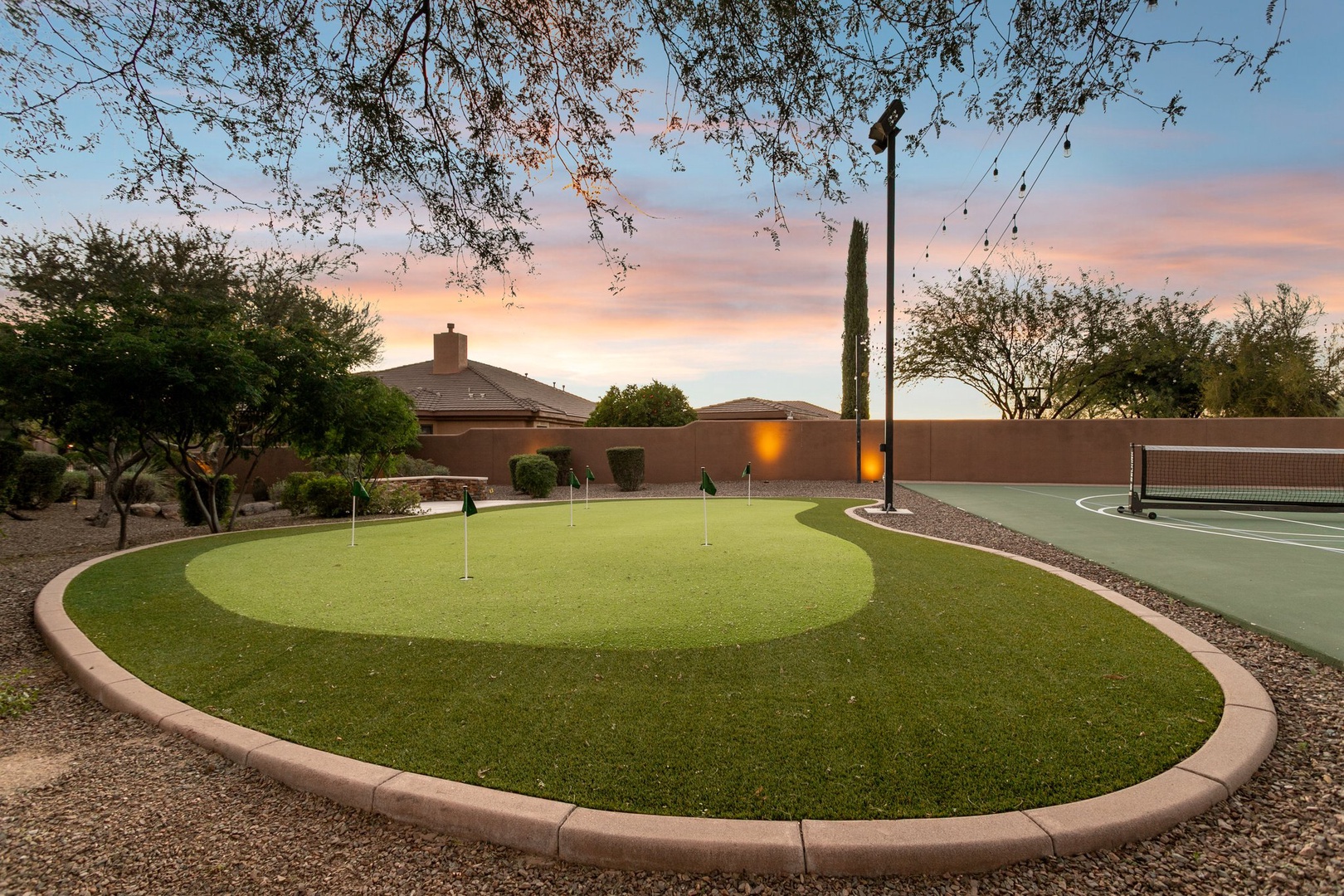 Private putting green and pickleball court create the perfect backyard oasis for active relaxation under desert skies.