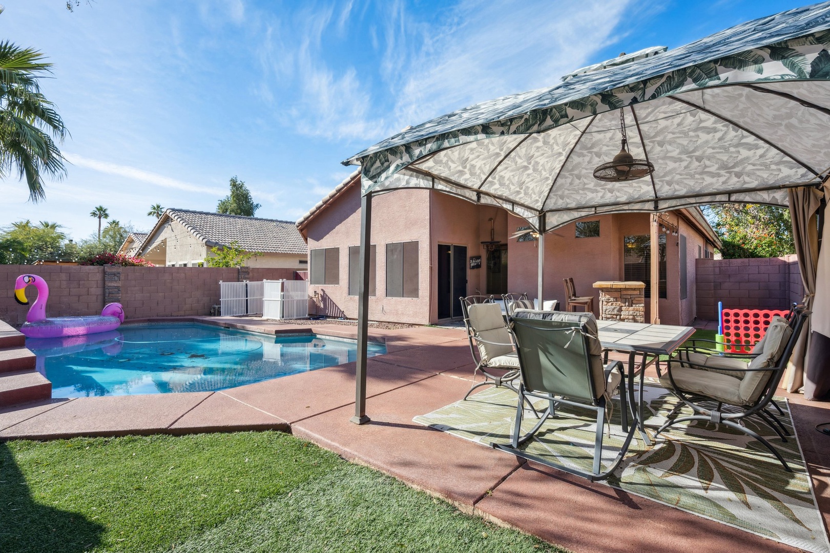 Relax under your private pavilion with pool views, outdoor dining, and sunny Arizona skies creating the perfect backyard retreat.