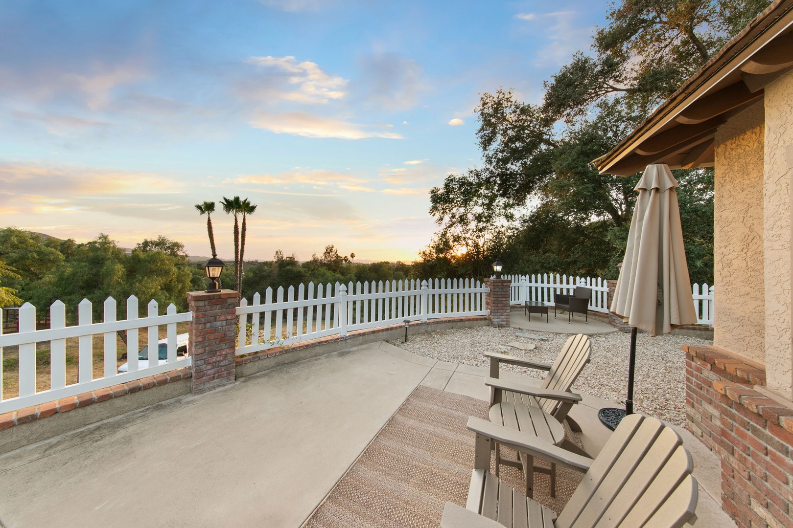 Your private patio beckons with comfortable Adirondack chairs and umbrella shade, perfect for morning coffee or sunset wine overlooking rolling hills.