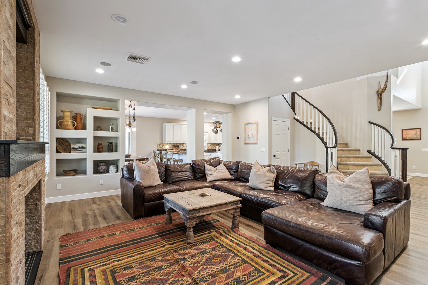 Sink into plush leather seating in your spacious living room, where rustic charm meets modern comfort beneath soaring ceilings.