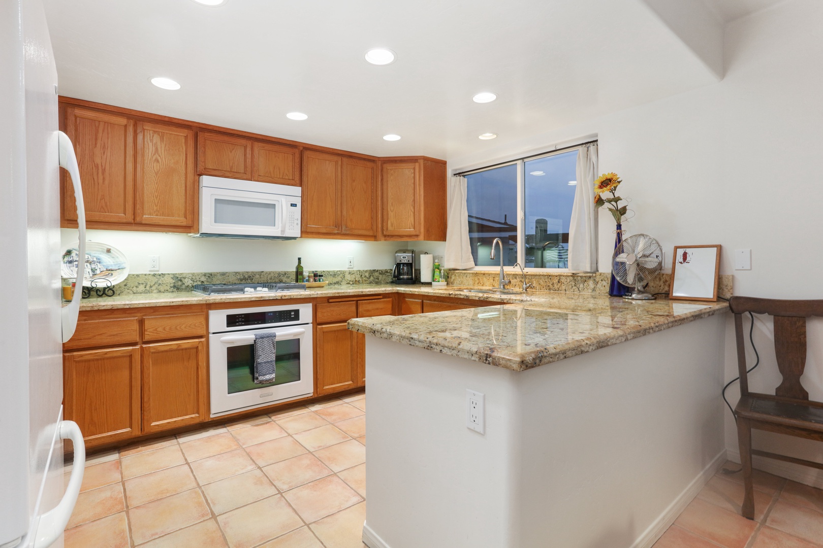 The kitchen provides modern appliances including: dishwasher, fridge, blender, stove top, coffee maker, pots and pans, utensils.