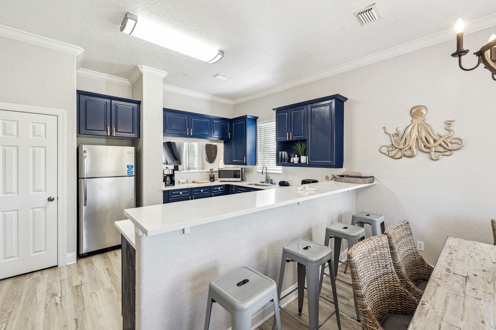 Your fully equipped kitchen features navy cabinets, stainless steel appliances, and a breakfast bar where you can gather for morning coffee.