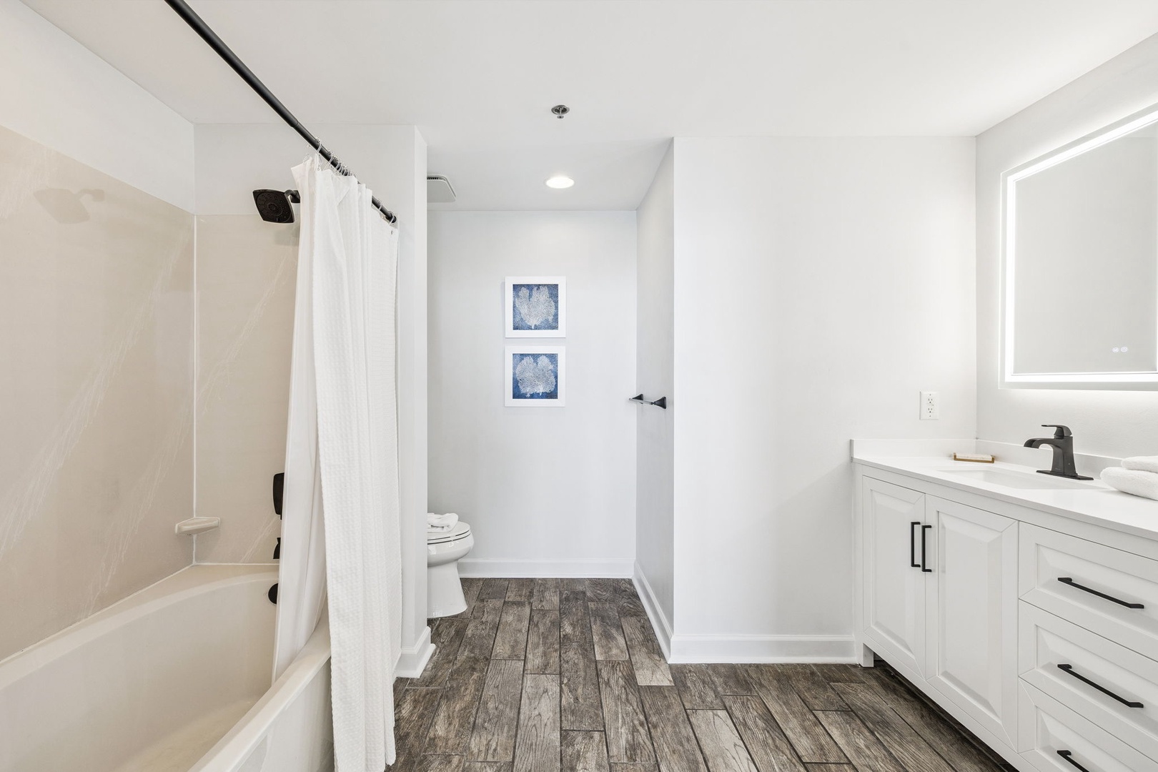 Unwind in your private spa-like bathroom featuring a deep soaking tub, spacious vanity, and coastal decor.