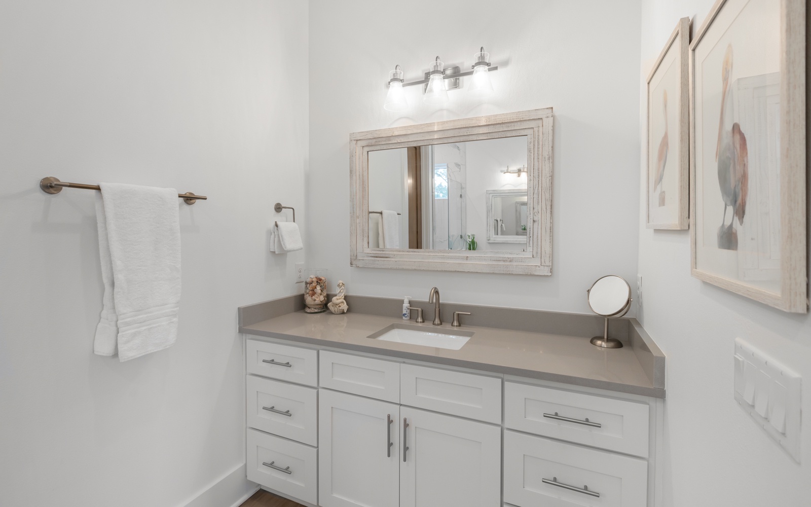 Step into your pristine bathroom retreat with elegant vanity, perfect lighting, and fluffy towels awaiting your arrival.