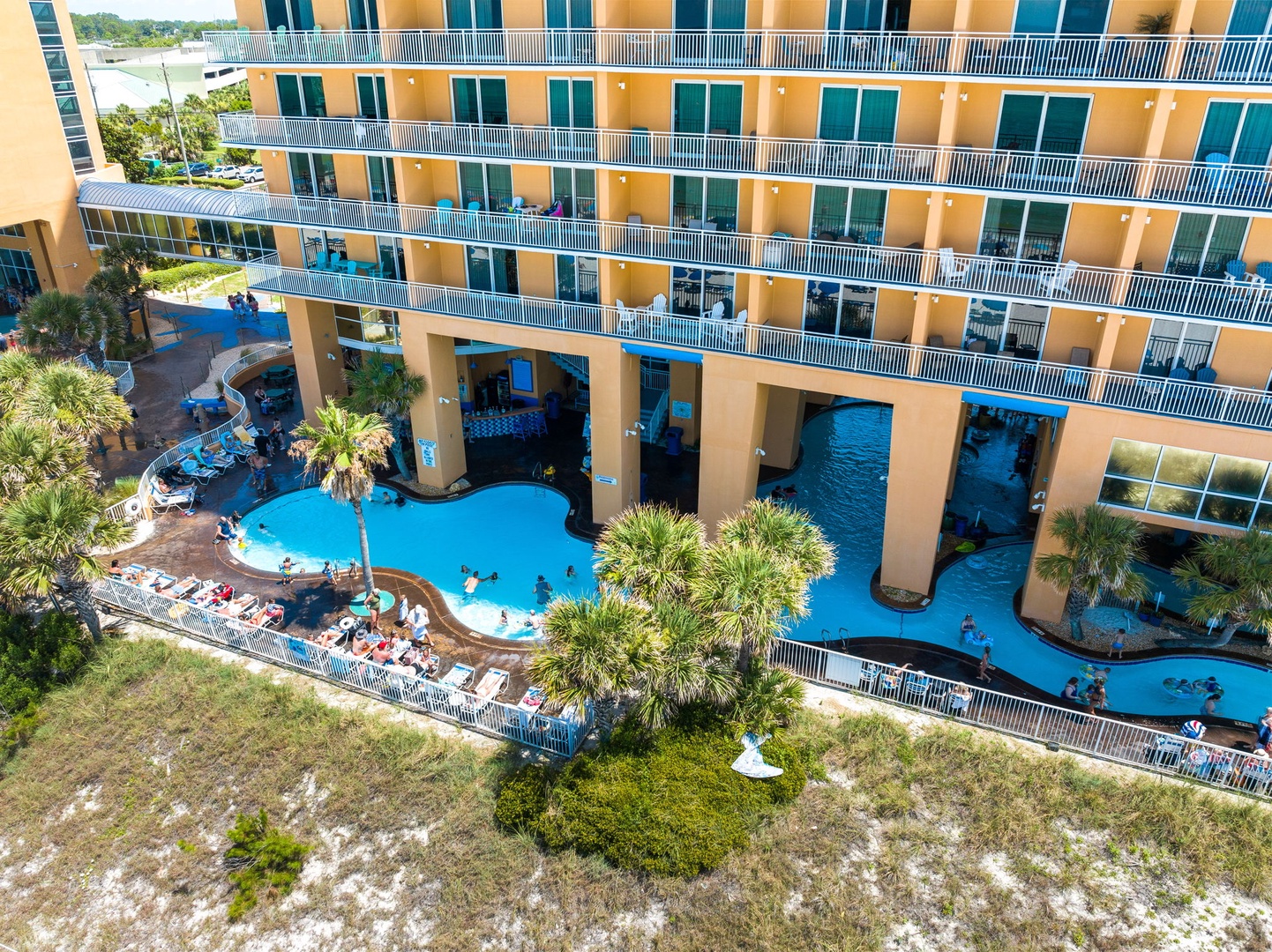 Aerial view of the resort property showcasing the multi-story building complex with expansive outdoor pool area and tropical landscaping.