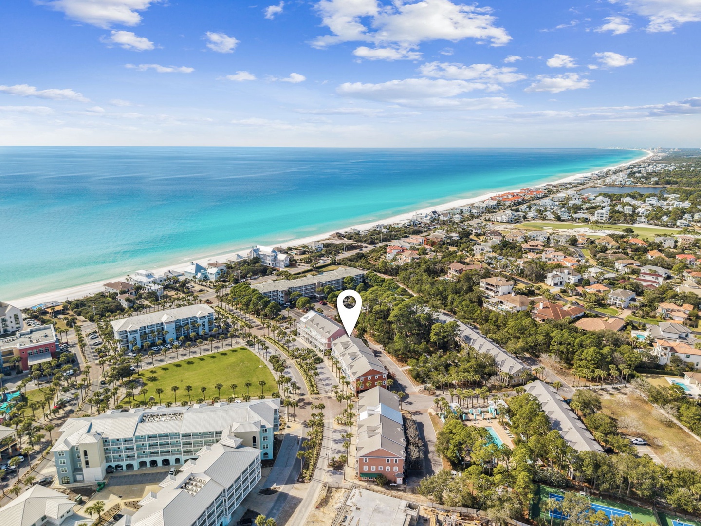 Aerial view of the coastal area featuring pristine turquoise waters, white sandy beach, and the property's prime location near the shore.