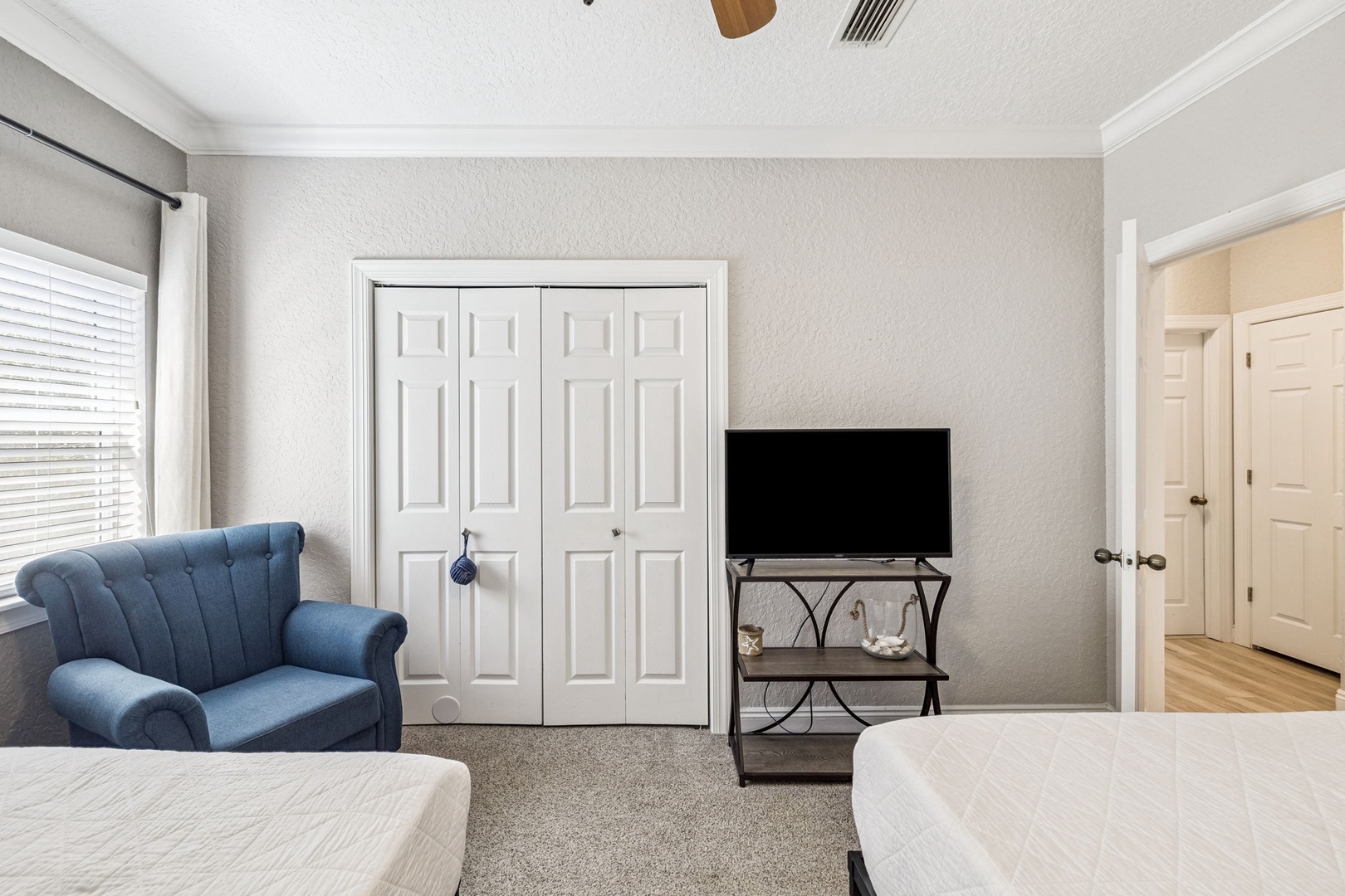Relax in your cozy bedroom with plush seating, entertainment center, and abundant natural light.