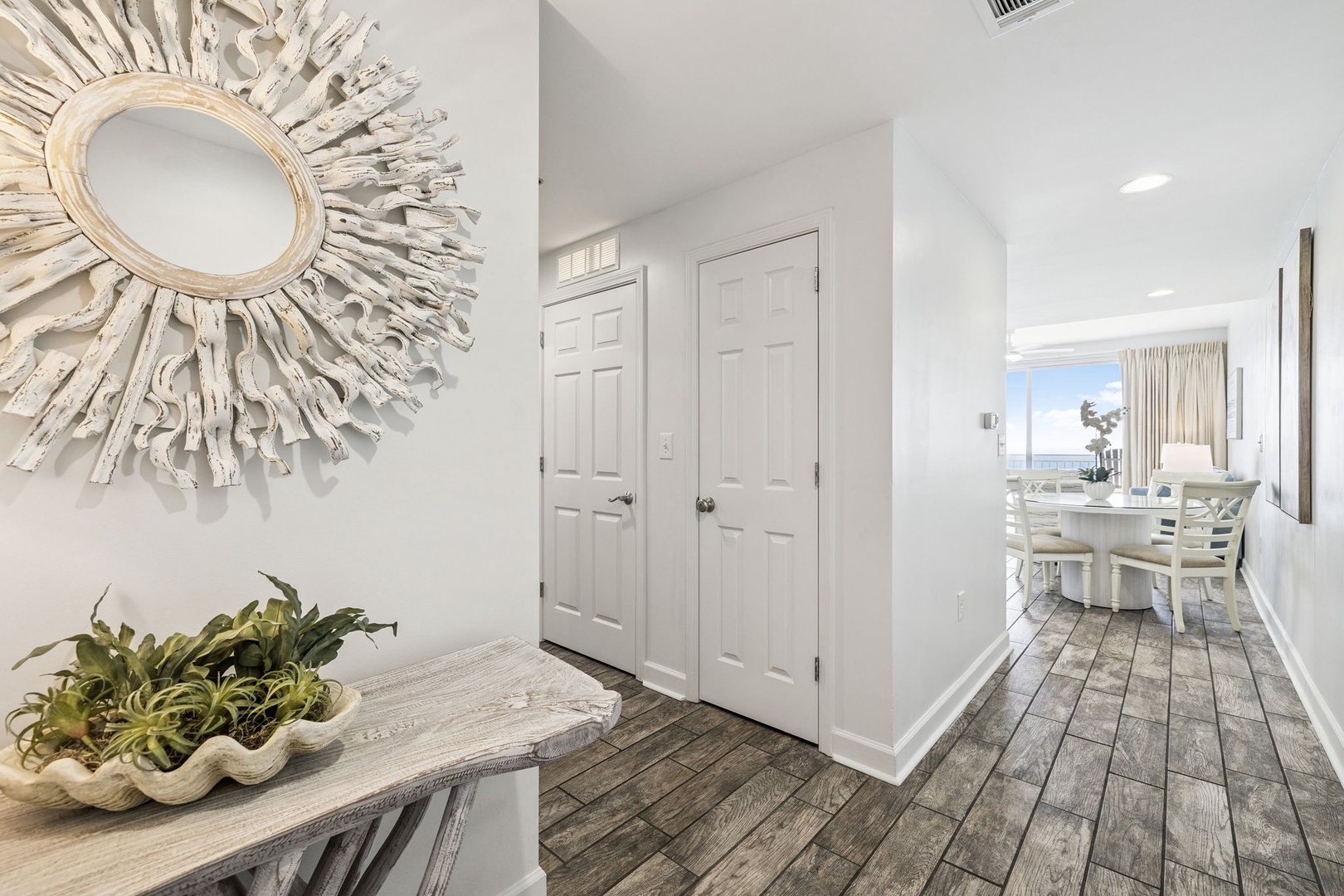 Step into your bright, coastal-inspired suite where elegant whitewashed décor and weathered wood floors create a serene beachside retreat.