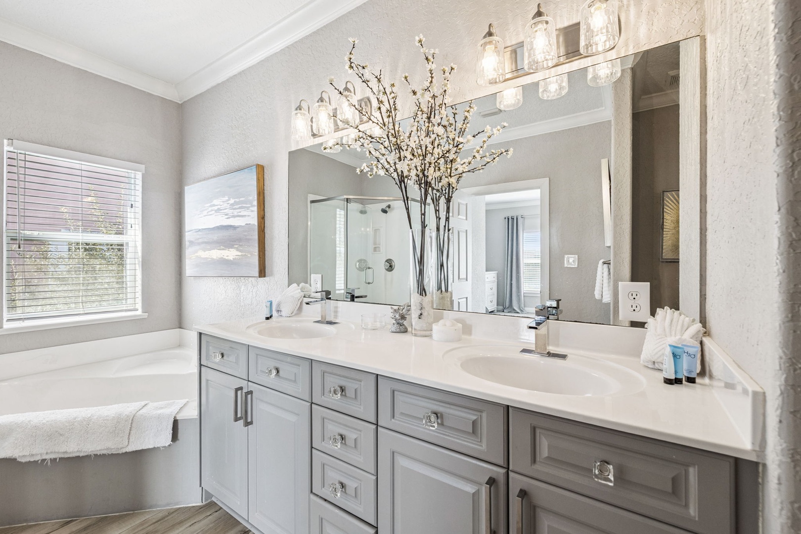 Refresh in your luxurious spa-like bathroom featuring elegant dual vanities, soaking tub, and thoughtful spring touches.