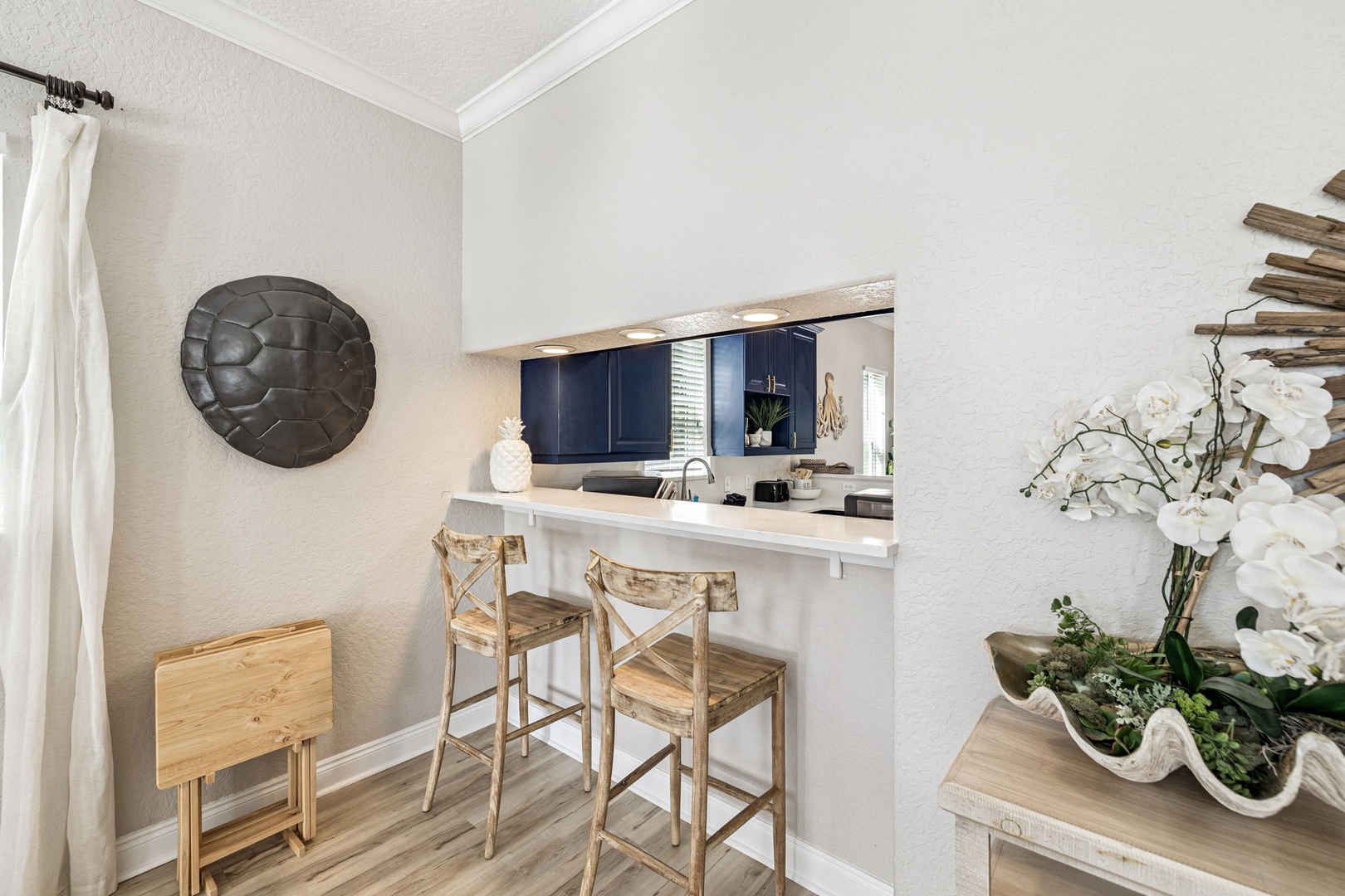 Savor your morning coffee at the breakfast bar with sleek navy cabinets and elegant lighting framing your culinary space.