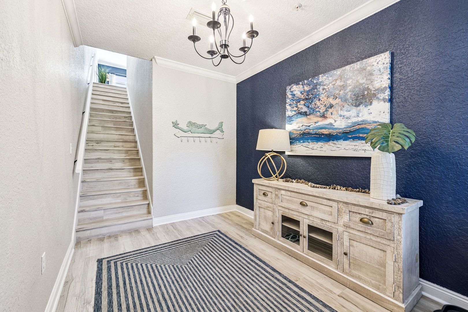Cozy coastal living space awaits with nautical artwork and warm lighting for your perfect getaway.