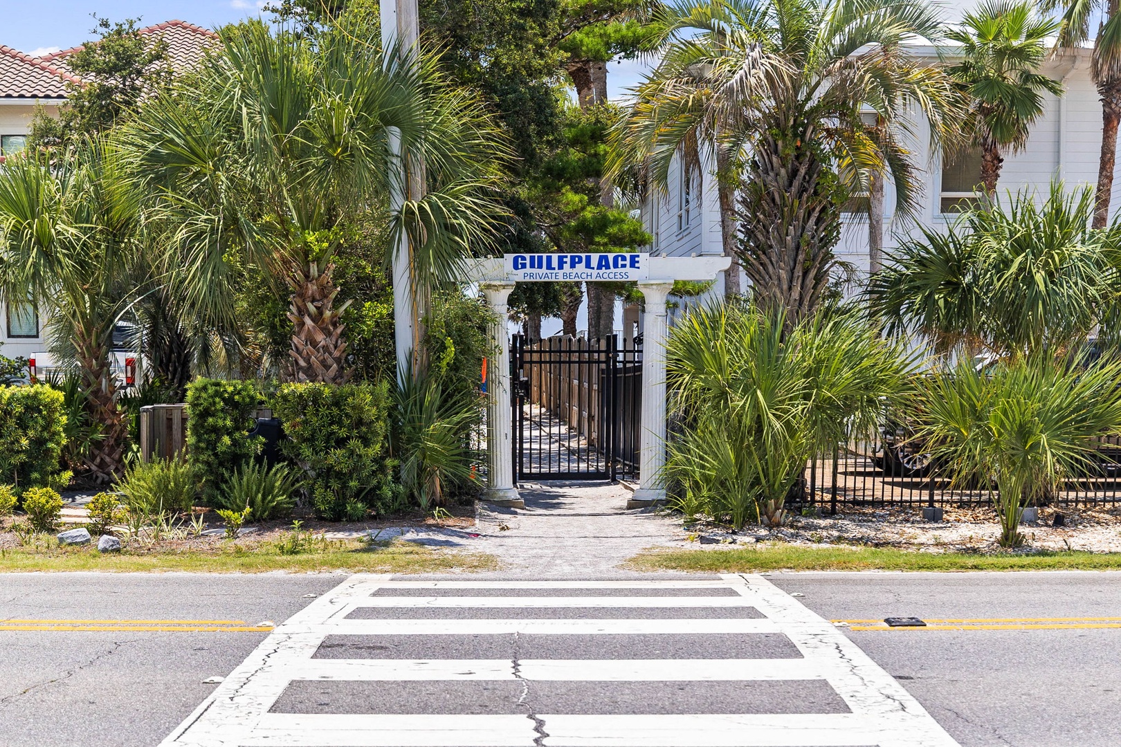 Gulfplace property entrance features tropical landscaping with palm trees and gated access in a peaceful residential setting.