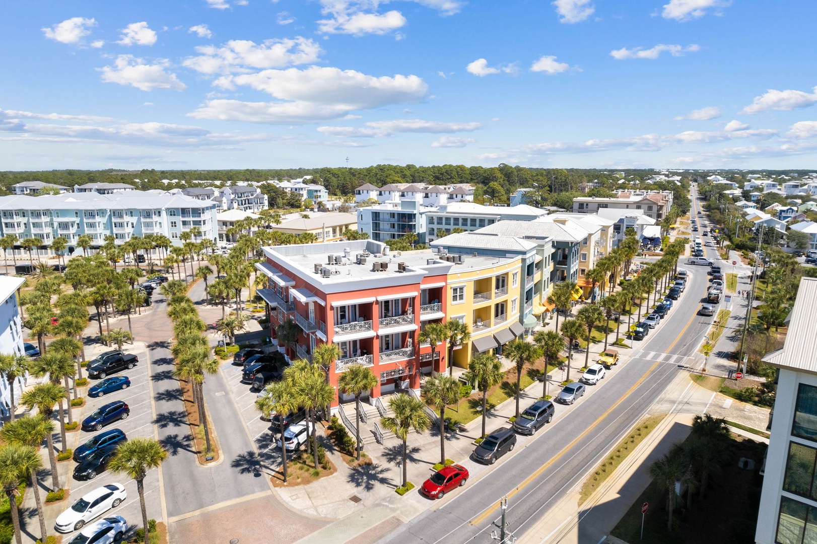 Aerial view of the vibrant neighborhood featuring colorful buildings, palm-lined streets, and nearby amenities within this coastal community.