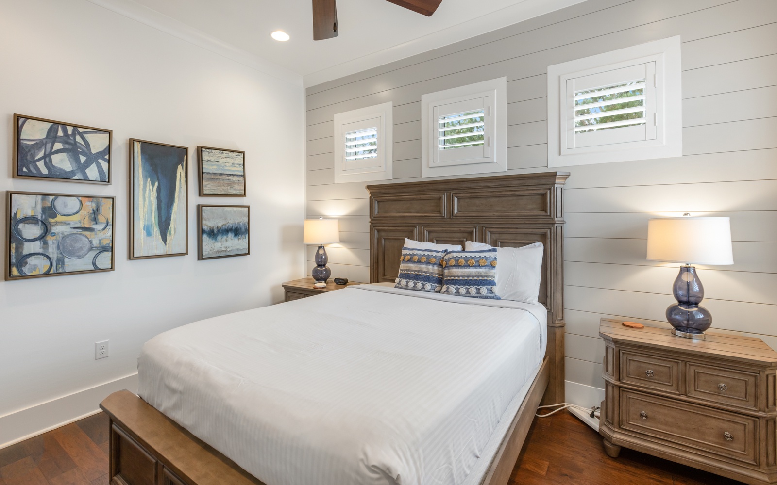 Drift into peaceful sleep in your cozy bedroom with crisp white linens and coastal artwork creating the perfect retreat.