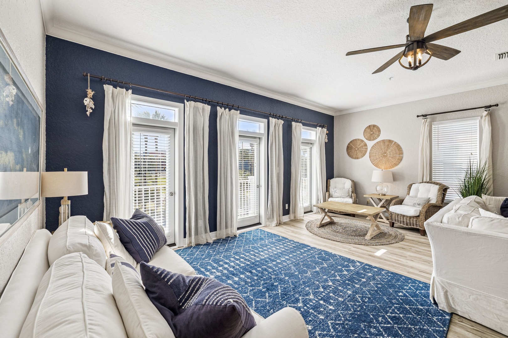 Unwind in this bright, coastal-inspired living room where navy accents and natural textures create your perfect relaxation retreat.