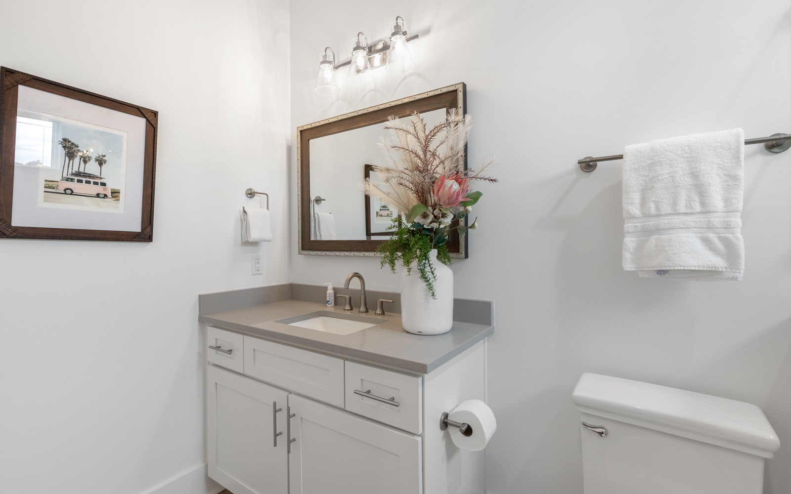 Freshen up in your stylish bathroom with modern fixtures, soft lighting, and fresh flowers welcoming you.