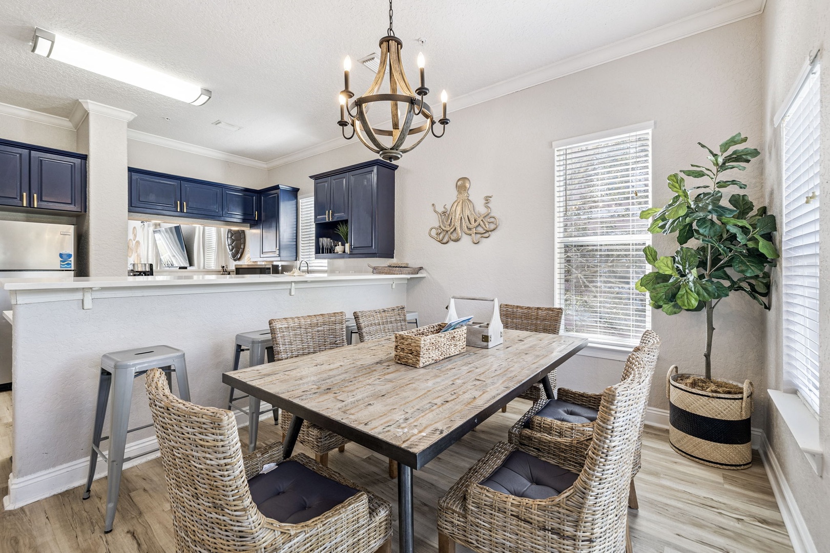 Gather around your elegant dining table for memorable meals in this bright, open space with stylish navy accents and modern fixtures.