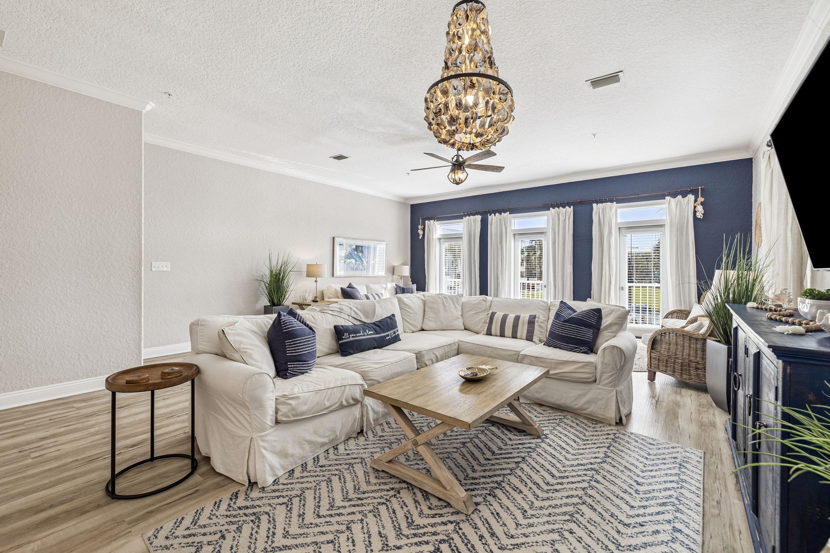Sink into this plush sectional beneath a stunning chandelier, where nautical touches and elegant finishes create your perfect retreat.