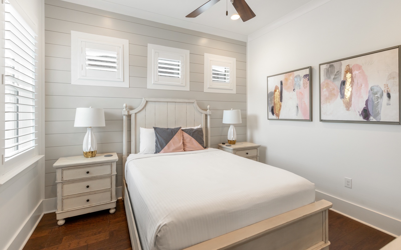 Your serene bedroom sanctuary awaits with crisp linens, coastal shiplap, and gentle ceiling fan breezes for peaceful nights.