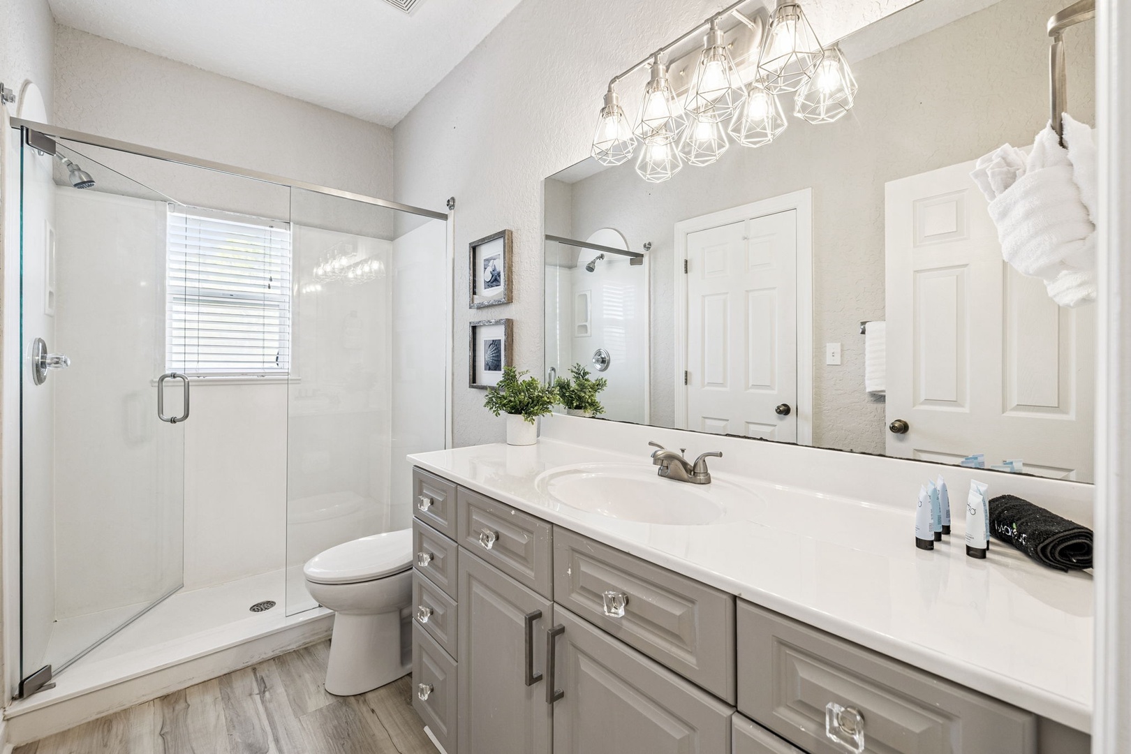 Your elegant ensuite awaits with a spacious glass shower, stylish vanity, and thoughtful touches like fresh linens and modern fixtures.