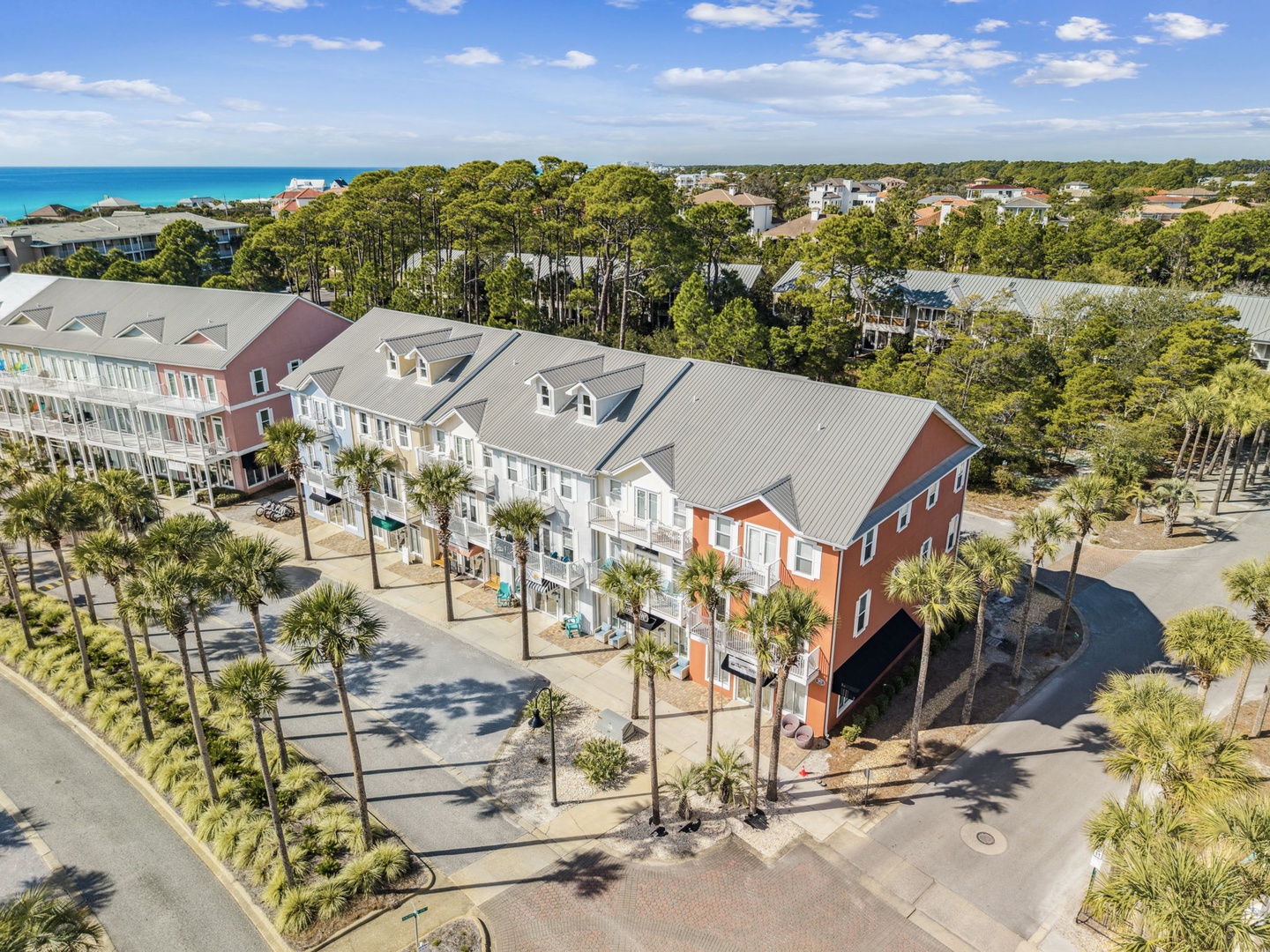 Coastal resort community featuring colorful townhomes surrounded by tropical palms, just steps from pristine beaches and turquoise waters.