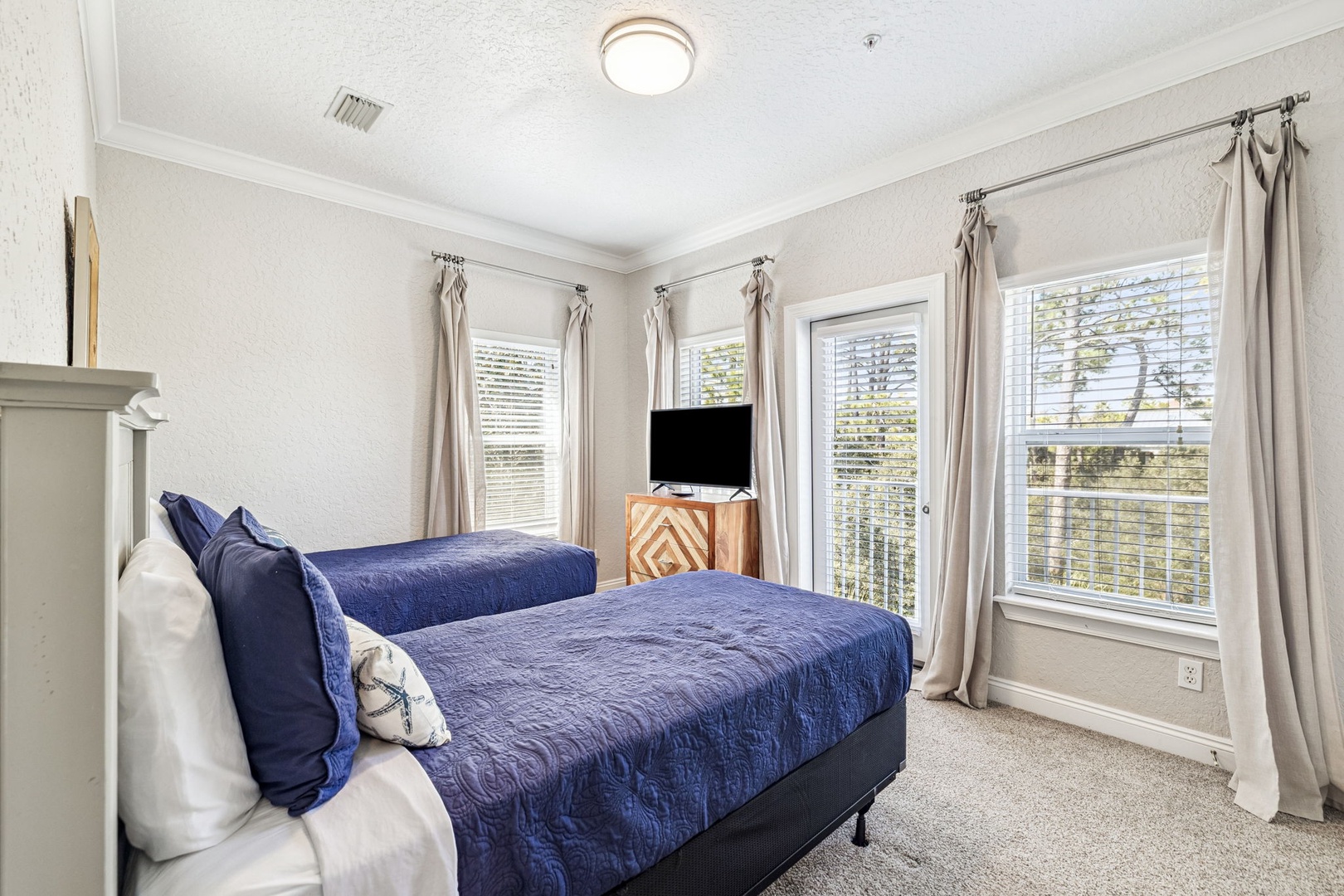 Rest peacefully in your bright twin bedroom with crisp linens and garden views through multiple windows.
