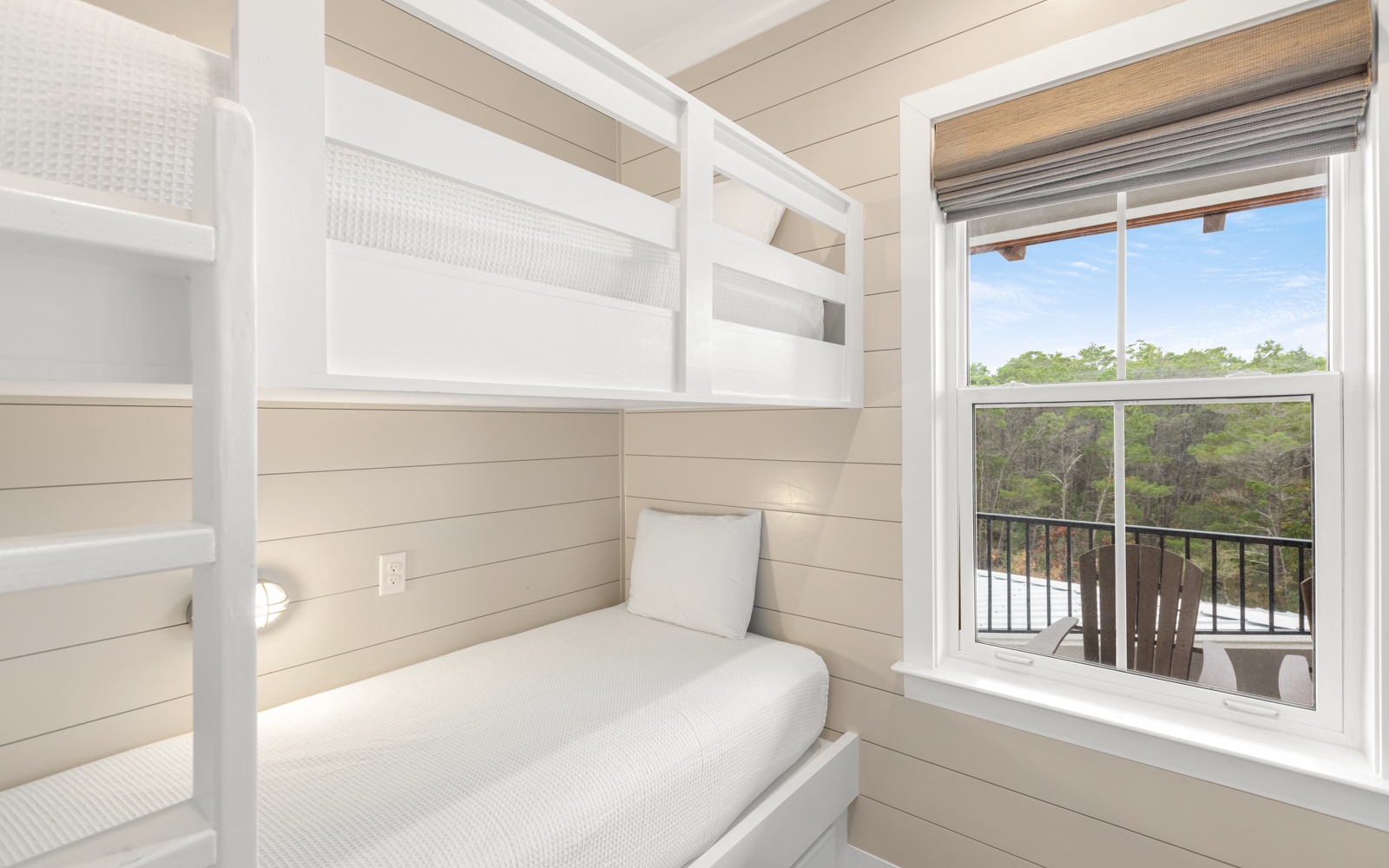 Your kids will love this bright bunk bed nook with treetop views and cozy built-in design perfect for restful nights.