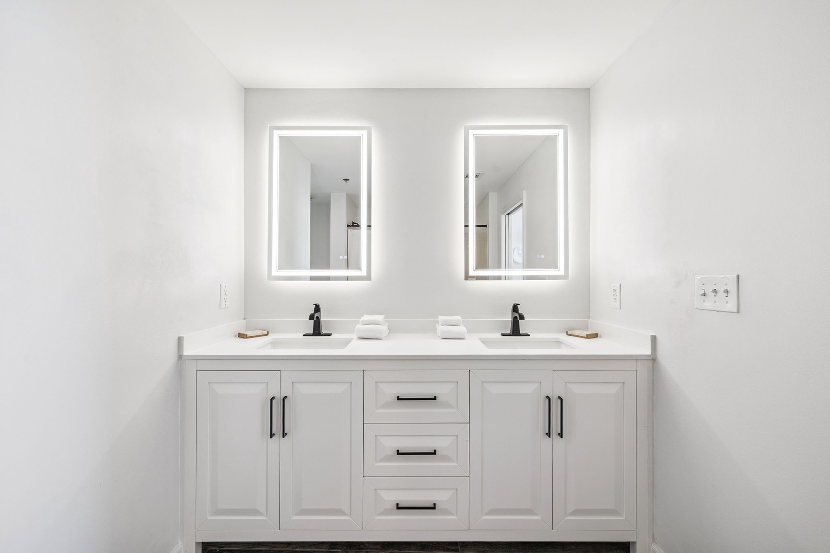 Enjoy your private spa-like retreat with dual vanity sinks, LED-lit mirrors, and sleek modern fixtures for your daily routine.