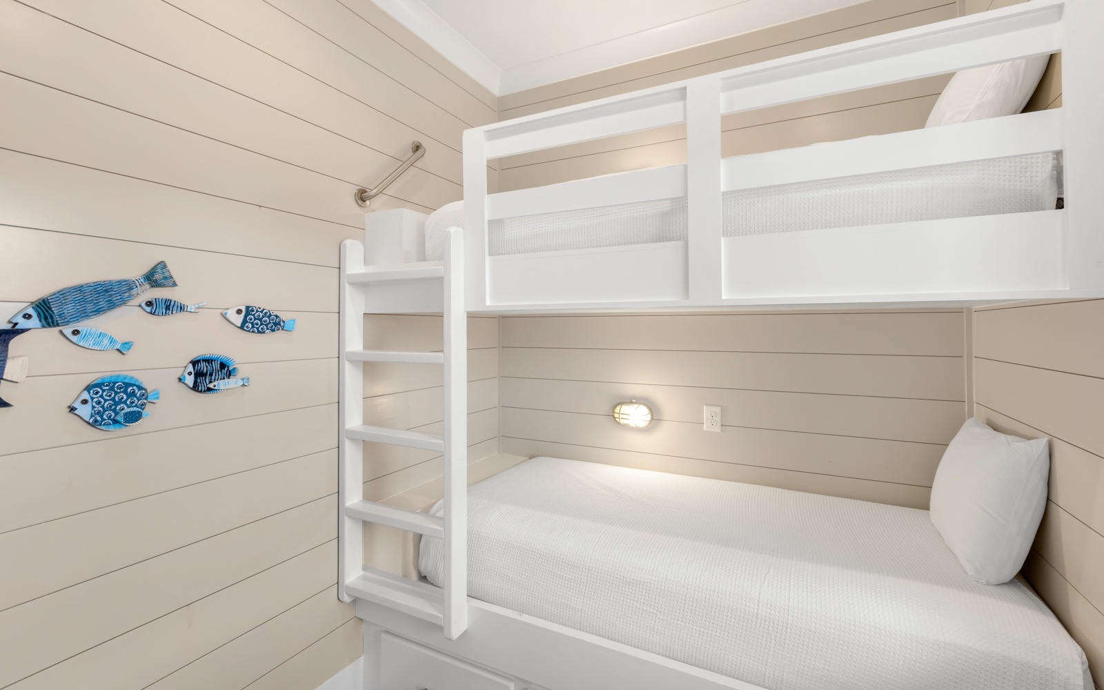 Your cozy bunk bed hideaway features cheerful fish art and personal reading lights for bedtime stories and peaceful sleep.