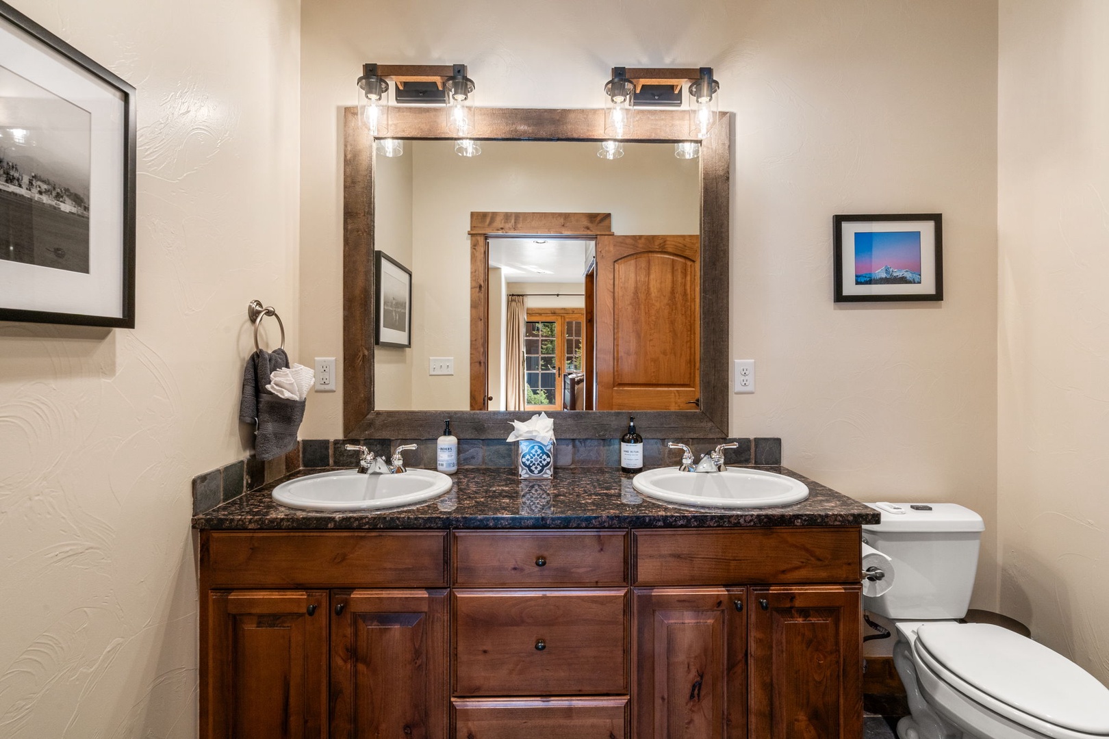 Your spacious bathroom features elegant dual vanities with granite countertops and rustic wood cabinetry, perfect for morning routines.