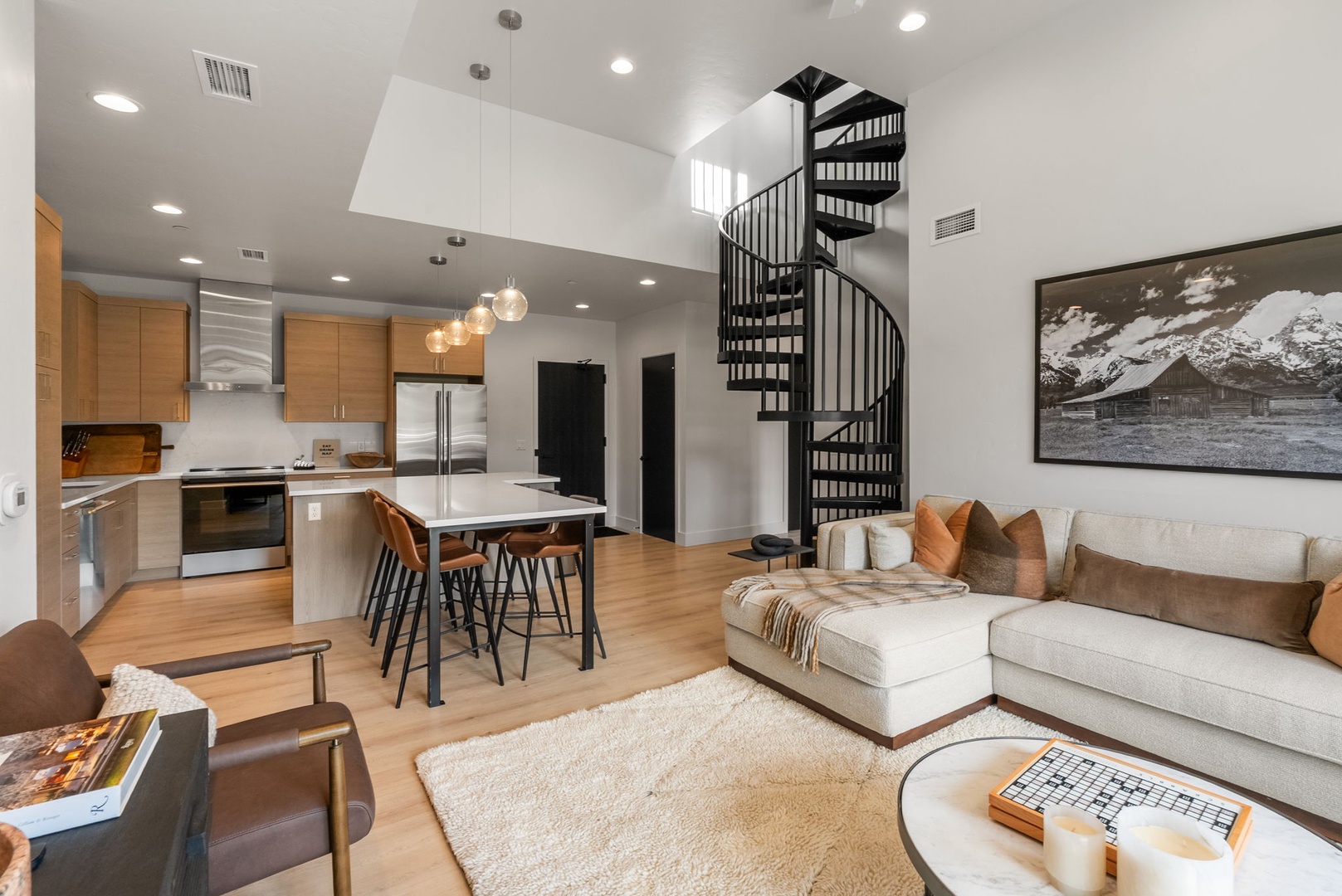 Settle into your open-concept retreat, where soaring ceilings and natural light create an inviting space. The spiral staircase and modern kitchen flow seamlessly into your comfortable living area, perfect for unwinding after a day of exploring.