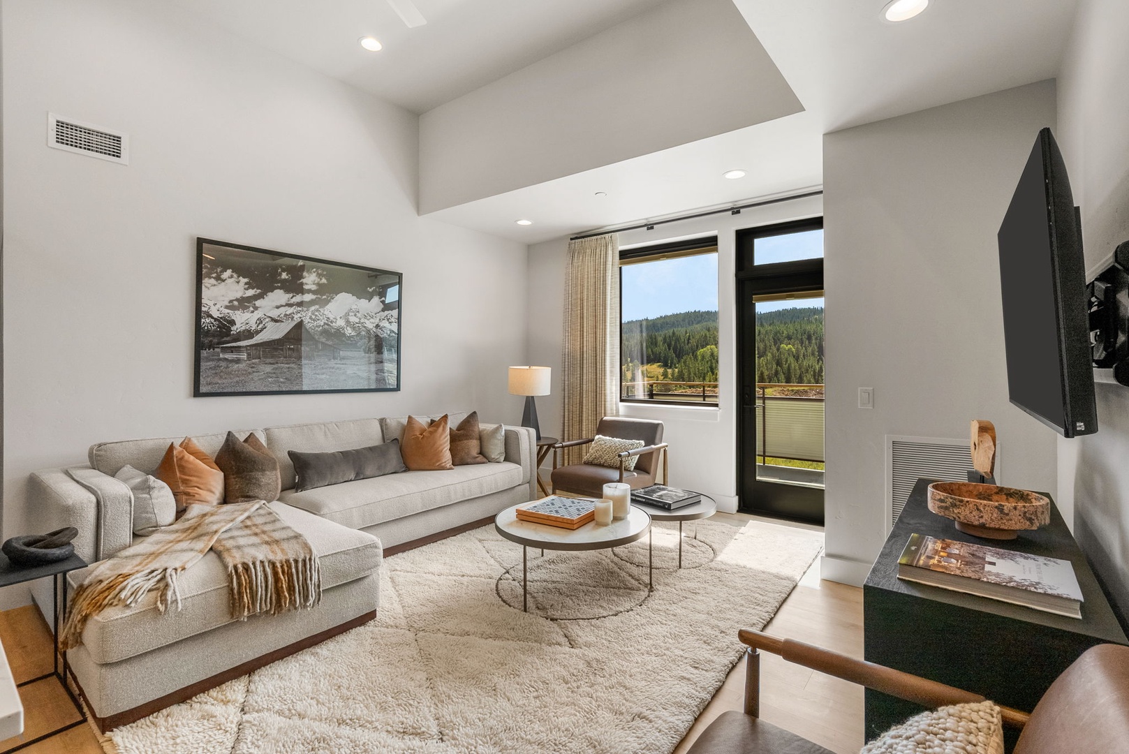 Settle into your bright, contemporary living space where soaring ceilings and floor-to-ceiling windows frame stunning mountain views. Step onto your private balcony and breathe in the fresh air.