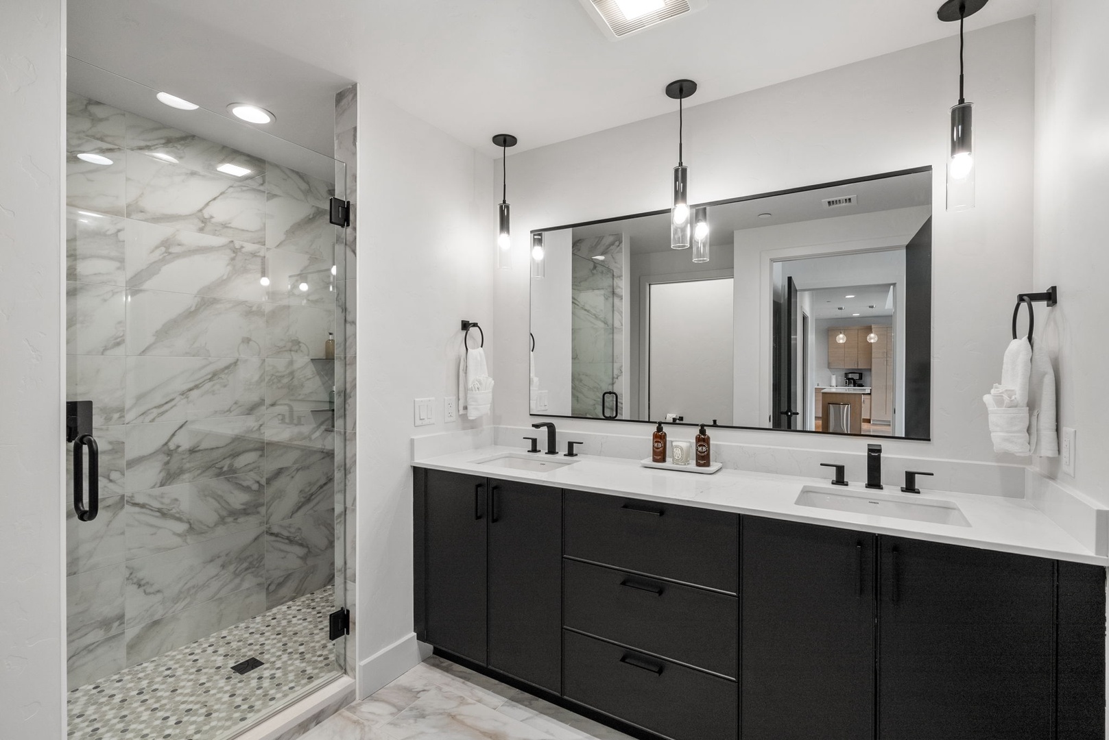 Step into your spa-like bathroom featuring a spacious walk-in shower with elegant marble surround and a sleek double vanity perfect for your morning routine.