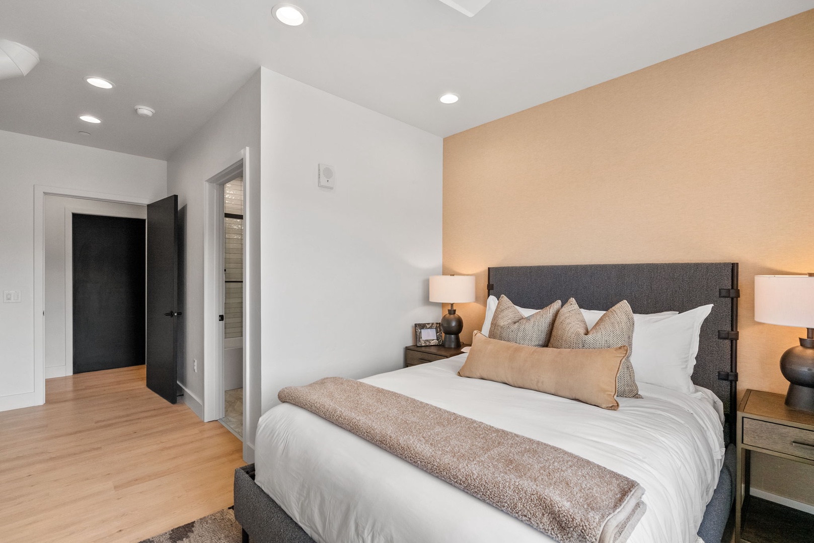 Sink into your plush bed after a day exploring, where warm lighting and soft linens create a peaceful retreat. The clean, modern design helps you unwind completely.