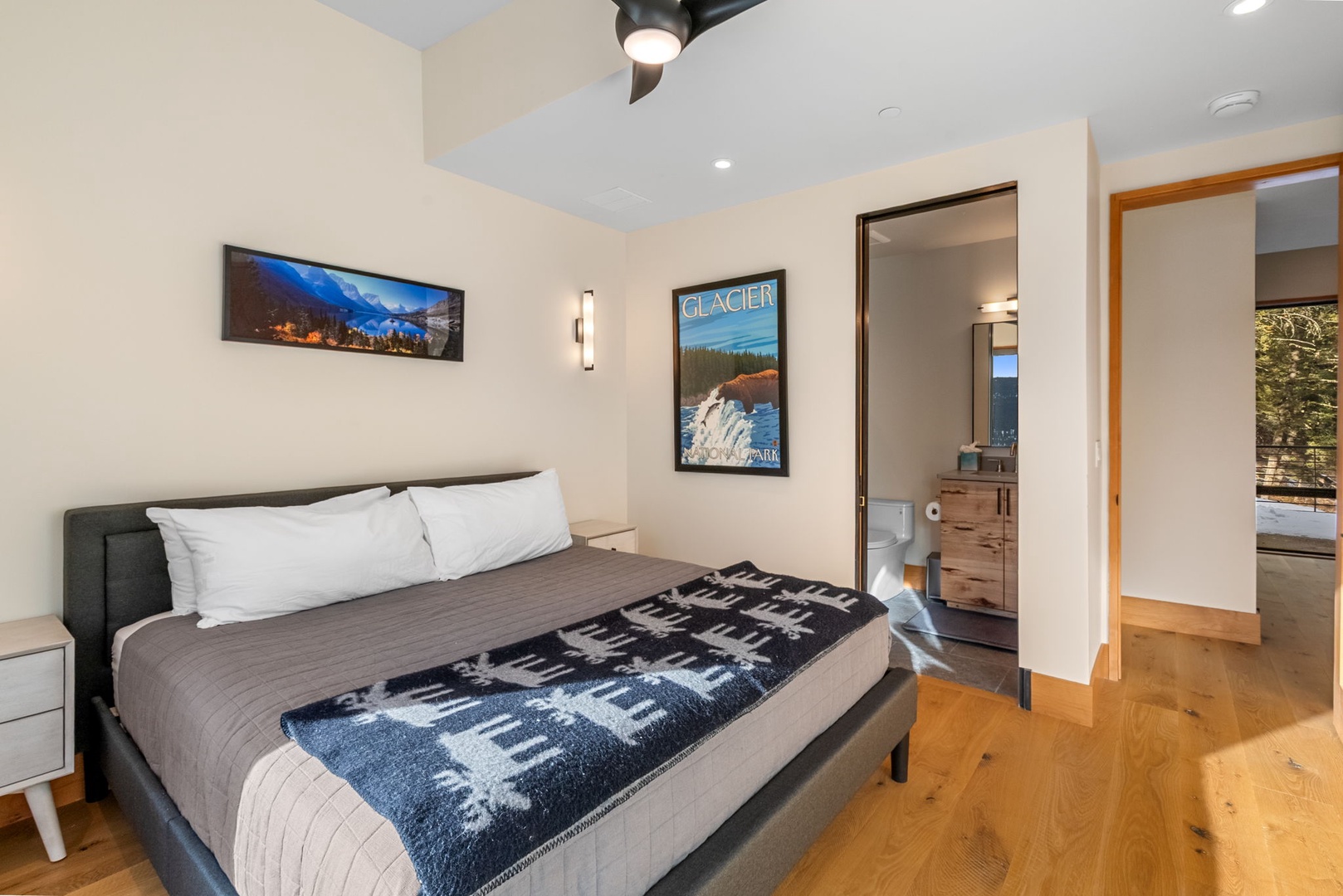 Rest peacefully in your modern bedroom featuring crisp linens, stylish mountain artwork, and an ensuite bathroom for your convenience.