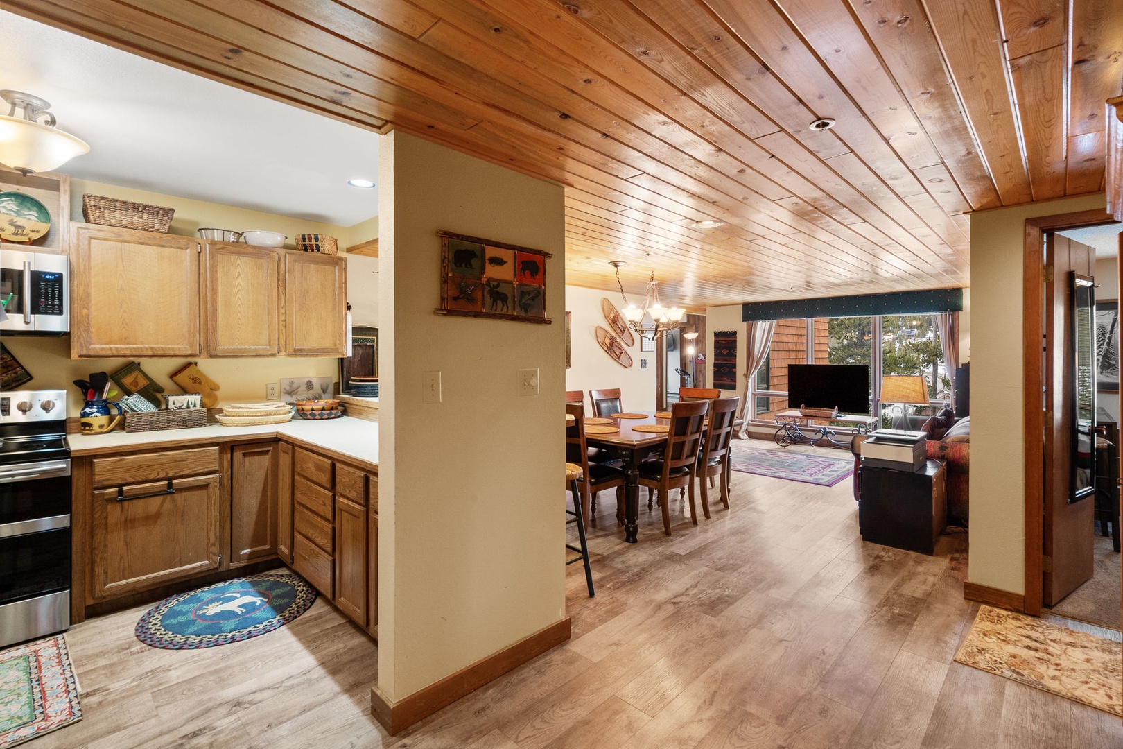 Your open-concept retreat features warm wood ceilings, a fully equipped kitchen, and inviting dining and living spaces perfect for memorable gatherings.