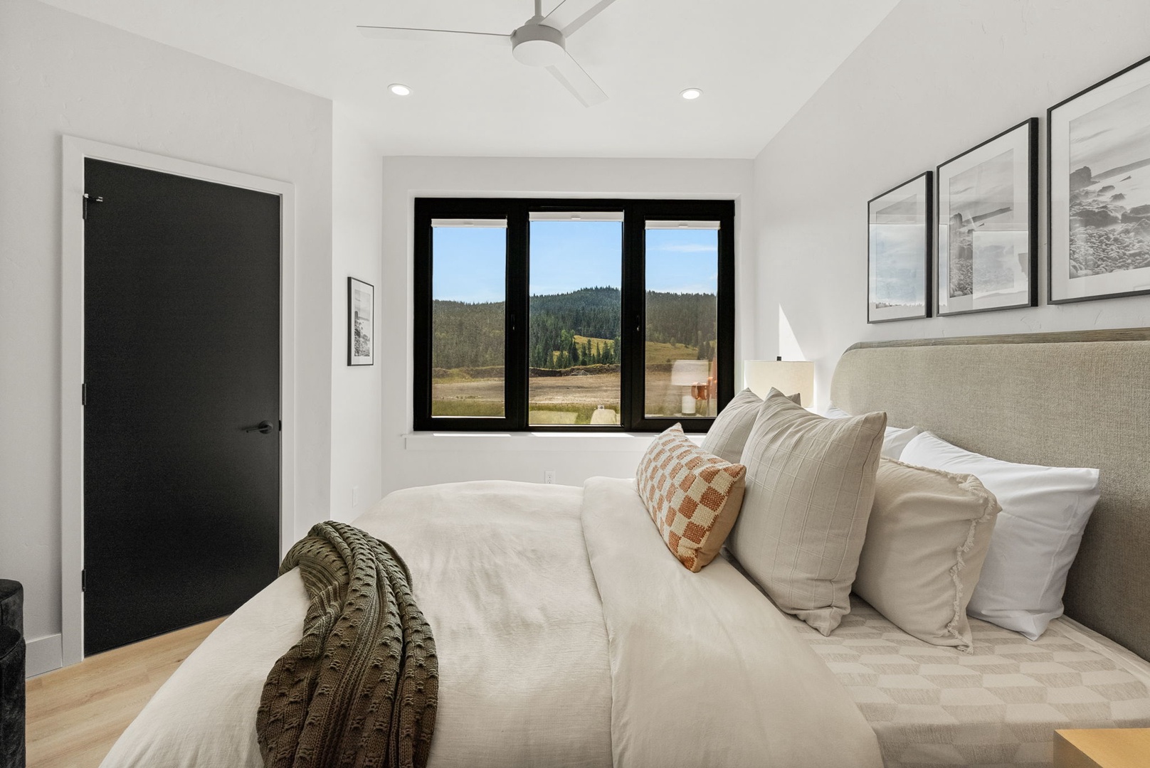 Unwind in your serene bedroom retreat, wrapped in soft linens and surrounded by calming neutral tones. Wake to breathtaking mountain views framed by large windows, filling your space with natural light and peaceful forest scenery.