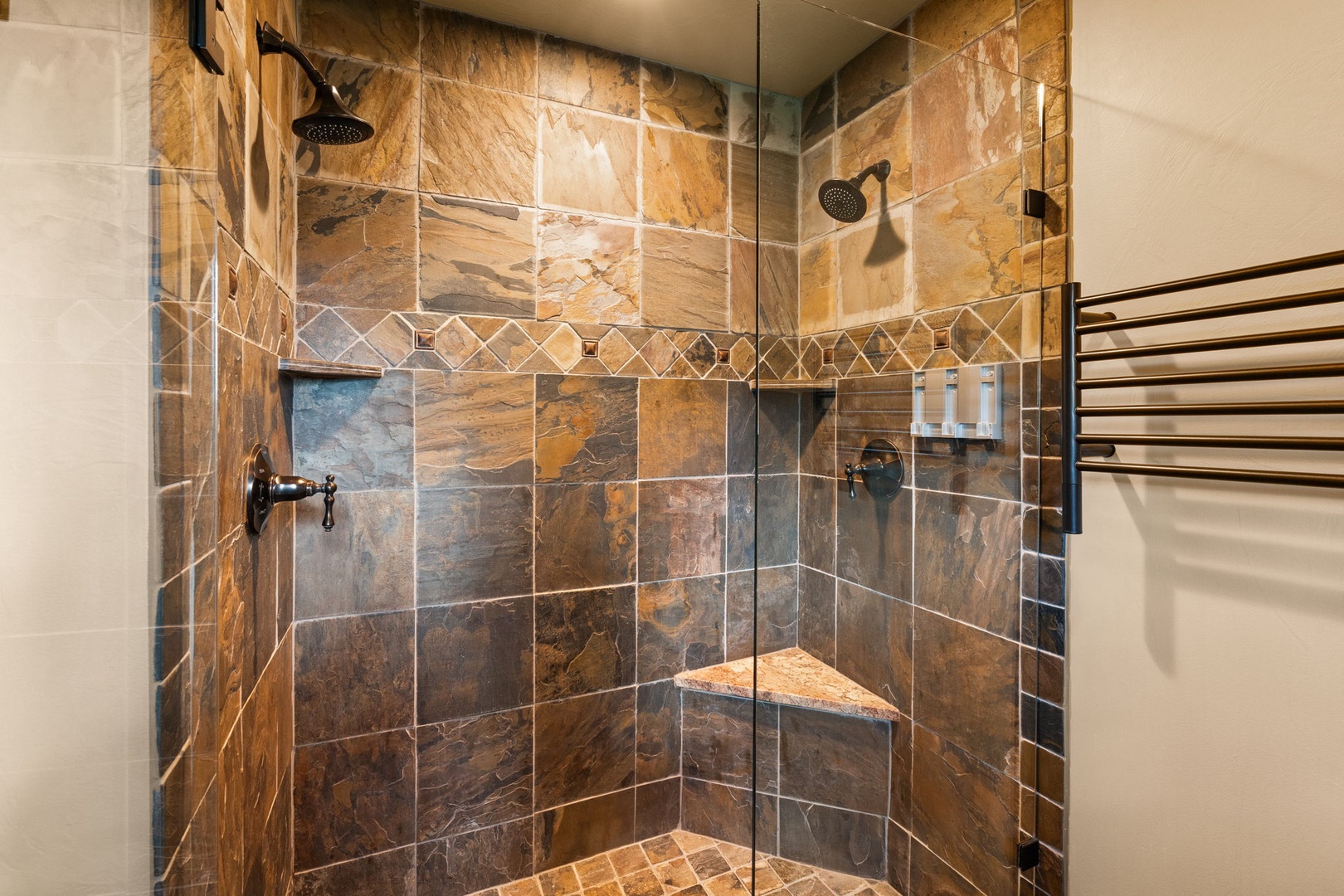 Step into your private walk-in shower with rich slate tile and dual rainfall showerheads for a spa-like experience every day.