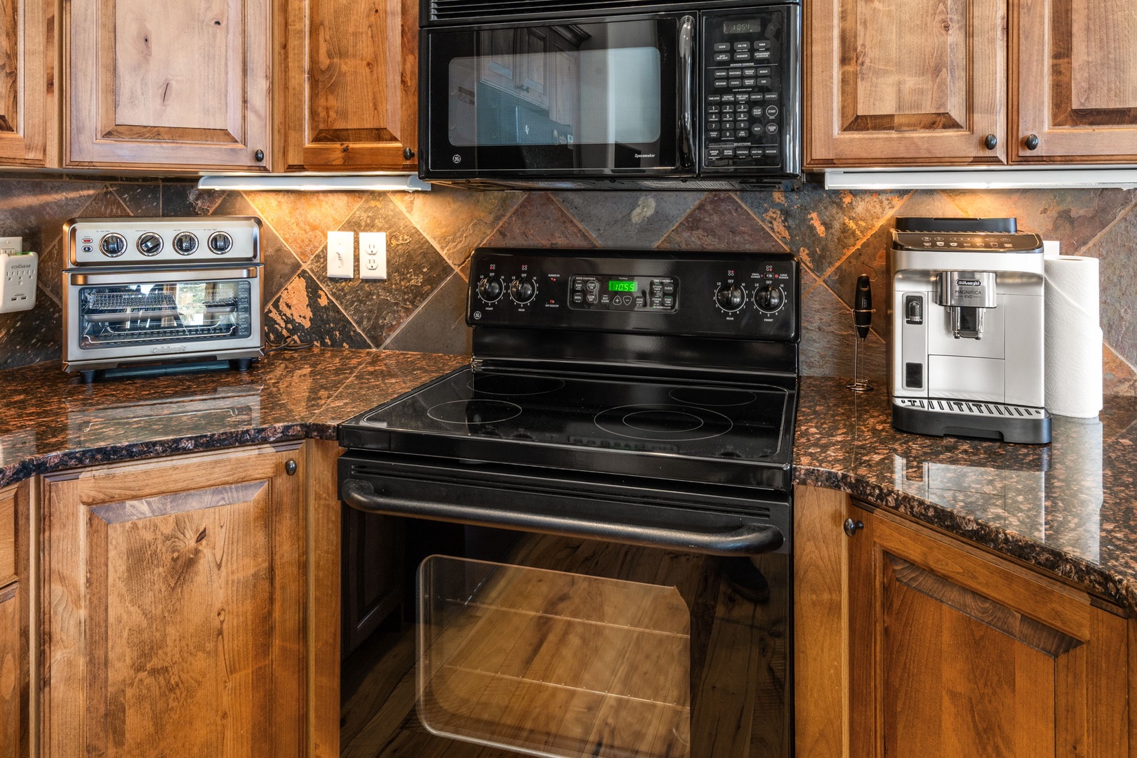 Cook your favorite meals in this fully equipped kitchen with granite countertops, modern appliances, and warm wood cabinetry.