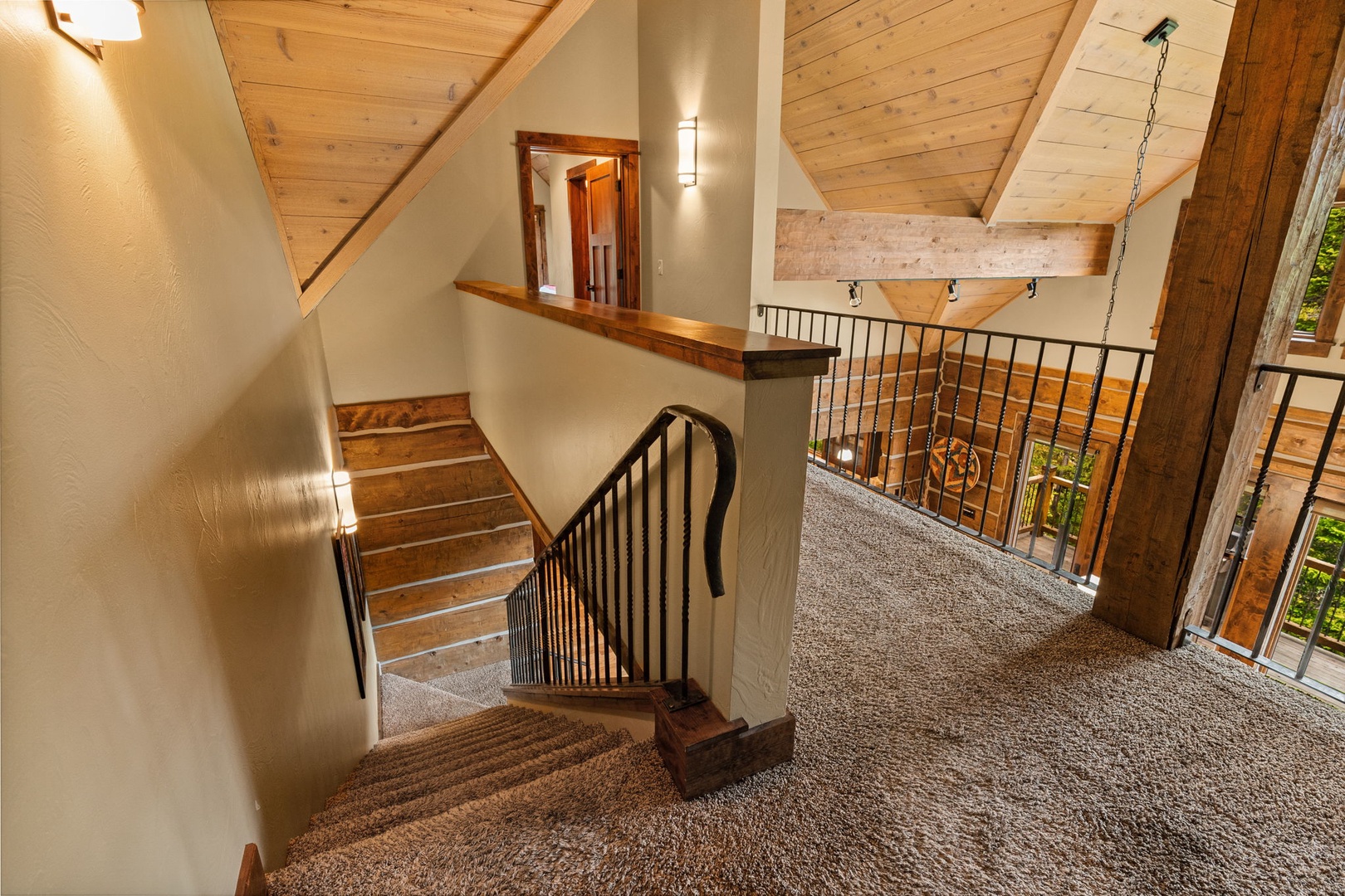 Rustic wood beams and vaulted ceilings create a warm, inviting atmosphere as you move through this charming mountain retreat with its cozy carpeted stairway and upper loft.