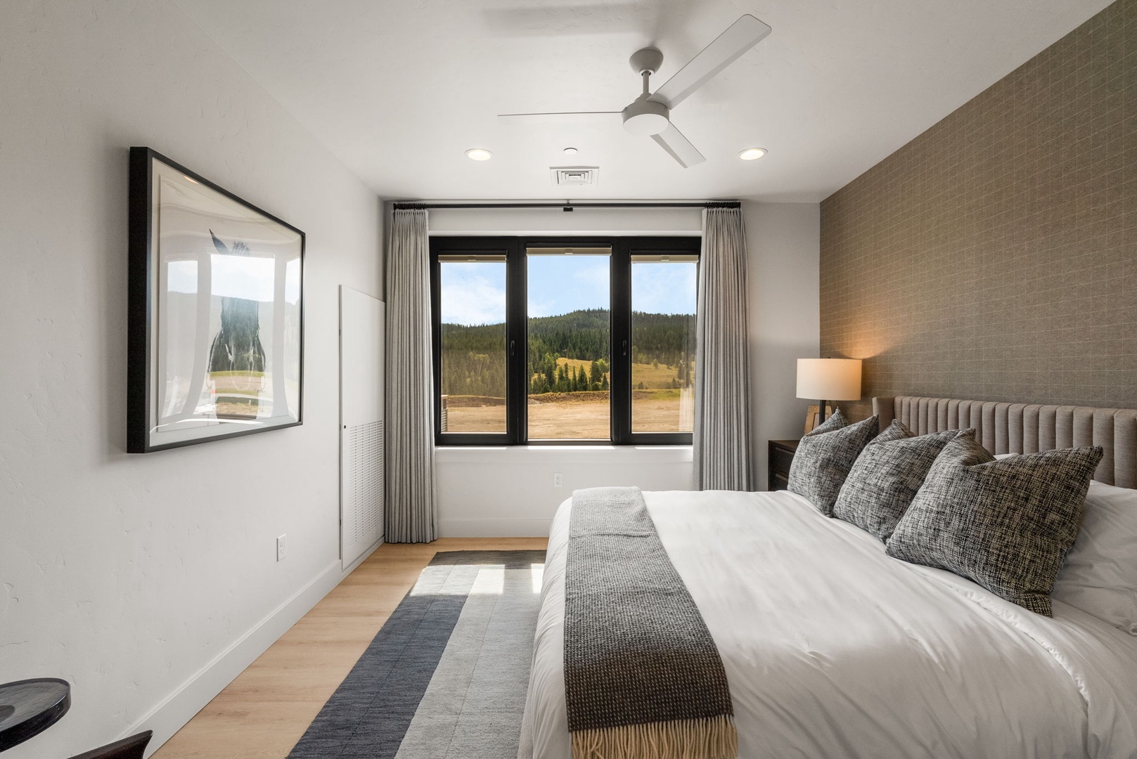 Wake up to stunning mountain views from your serene bedroom, where comfort meets natural beauty. The plush bed and soothing tones create a peaceful retreat, perfect for unwinding after a day of adventure.