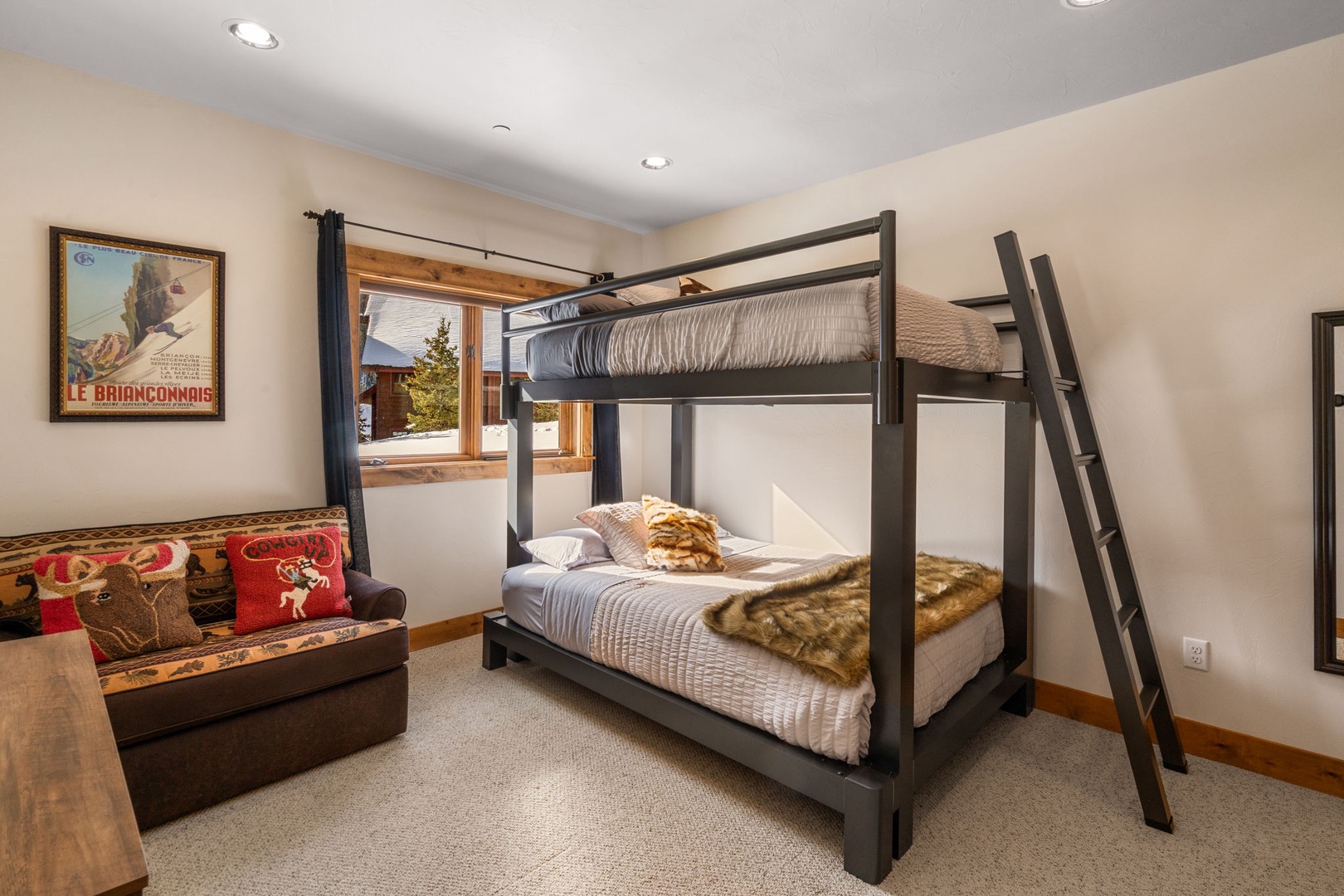 Your cozy mountain retreat features warm bunk beds and a comfy sofa, perfect for family bonding after alpine adventures.