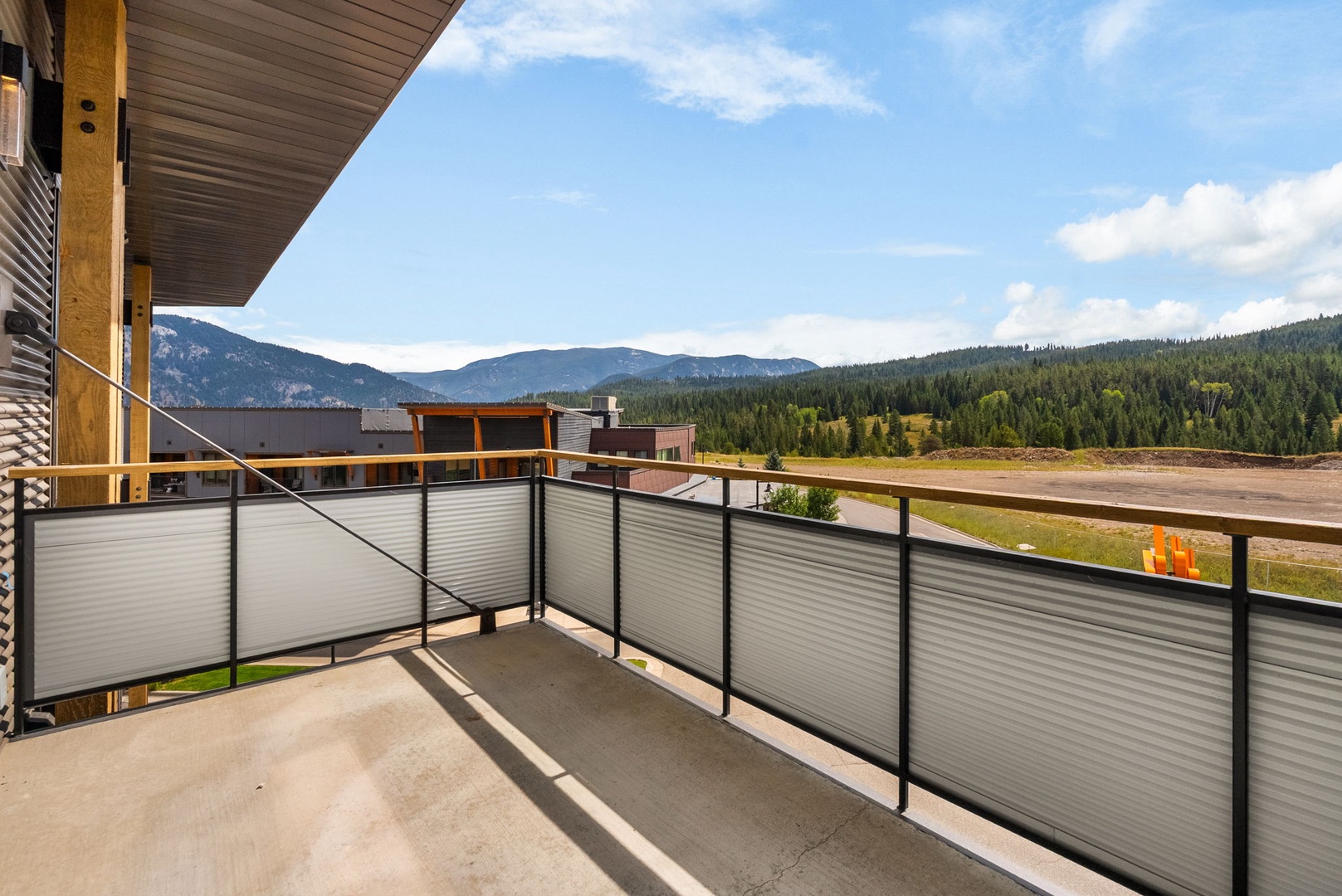 The private balcony offers sweeping views of forested ridges and open mountain terrain. The property is nestled within a peaceful natural setting, ideal for a serene mountain getaway.