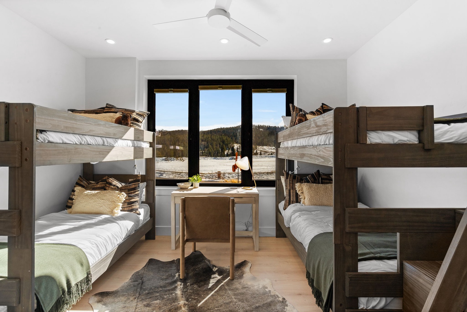 Your cozy bunk room features mountain views, perfect for family adventures. Rustic wood bunks with soft linens create a cabin retreat.