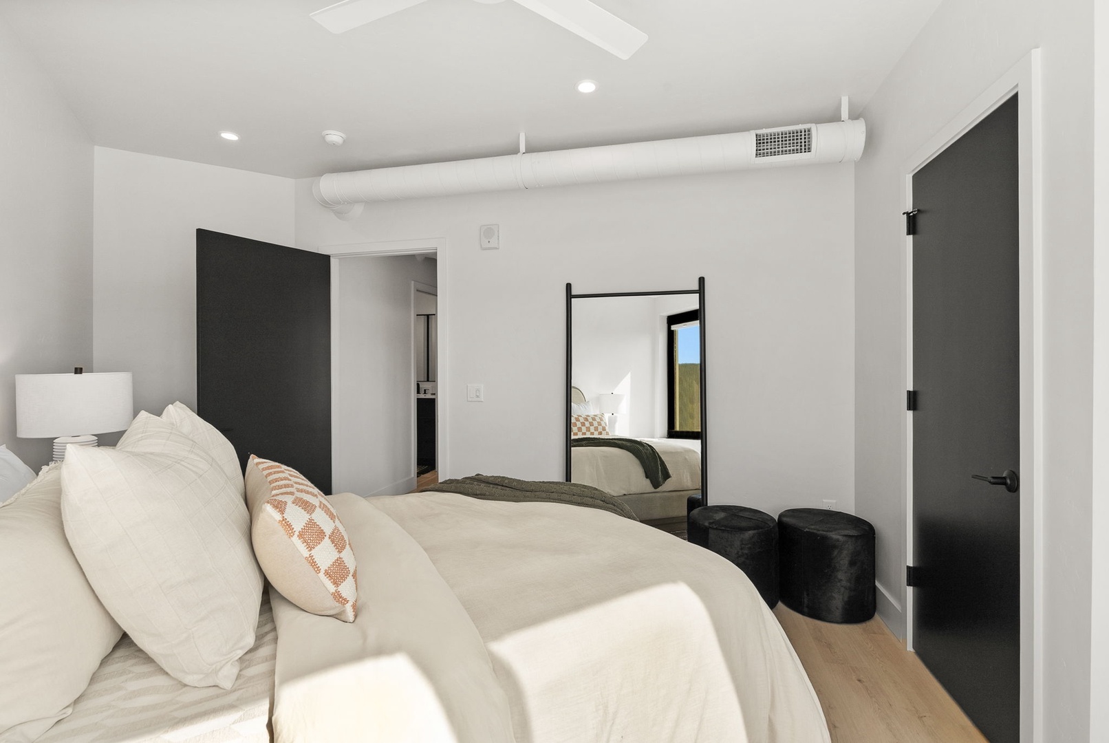 Slip into this serene bedroom where crisp whites and modern lines create your perfect retreat. Plush bedding invites restful nights, while the sleek design and natural light promise peaceful mornings in your private oasis.