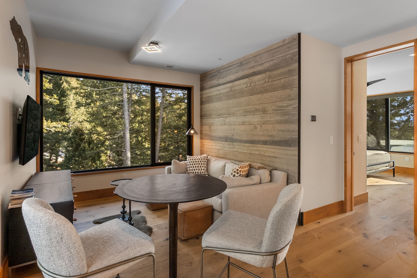 Relax in your modern living space with forest views and cozy seating for intimate conversations.