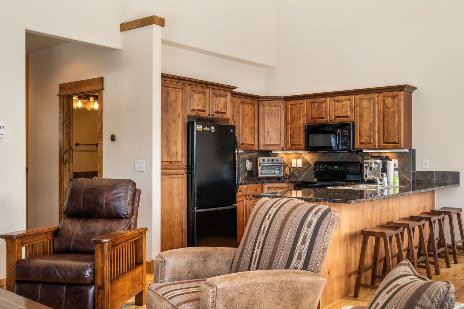 Settle into your spacious open-concept living area where rustic wood cabinets and granite counters create the perfect mountain retreat kitchen.
