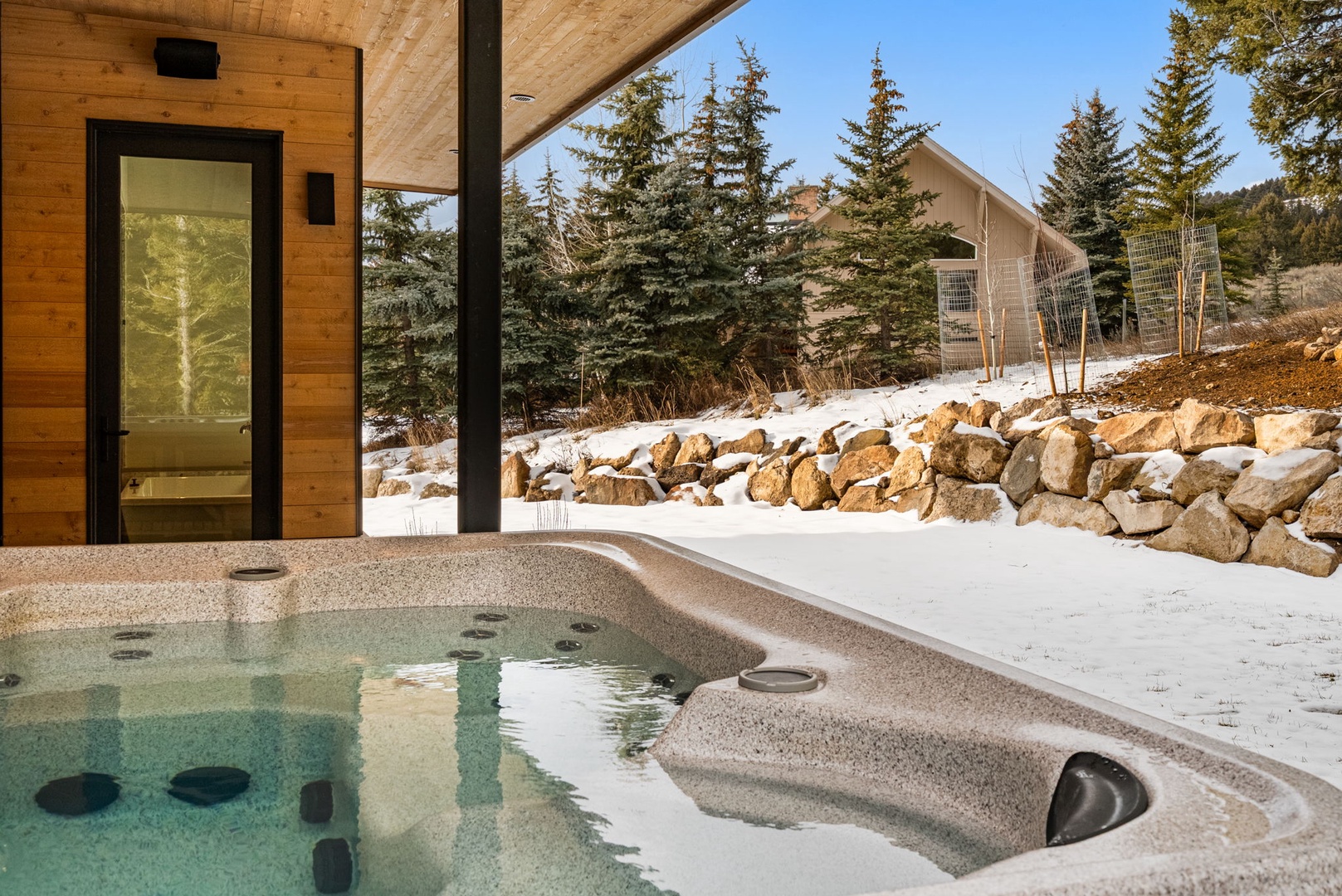 Relax in your private hot tub overlooking snow-dusted pines and mountain scenery—pure alpine bliss awaits.