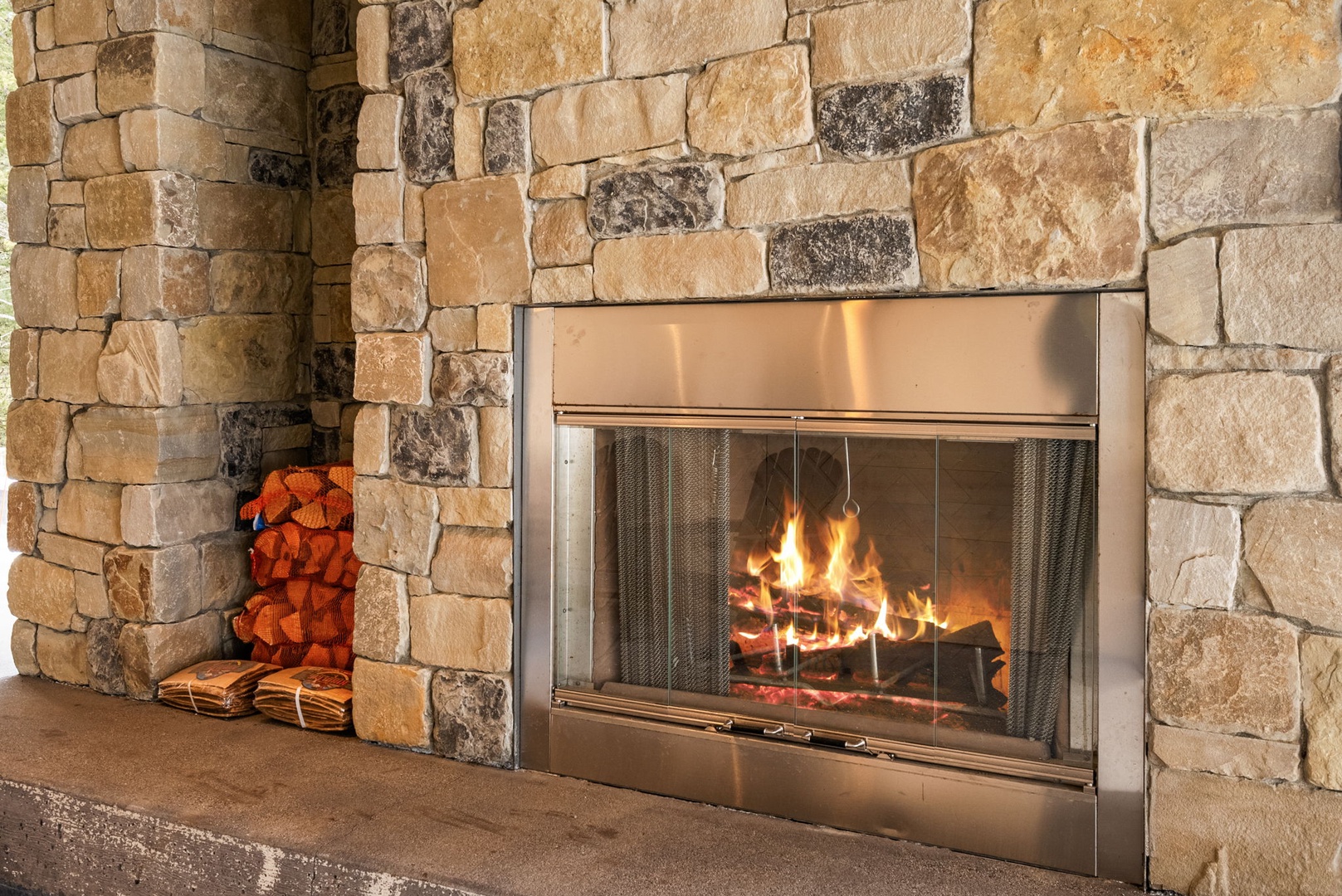 Cozy up by your private stone fireplace with crackling flames and ready firewood for perfect evening relaxation.