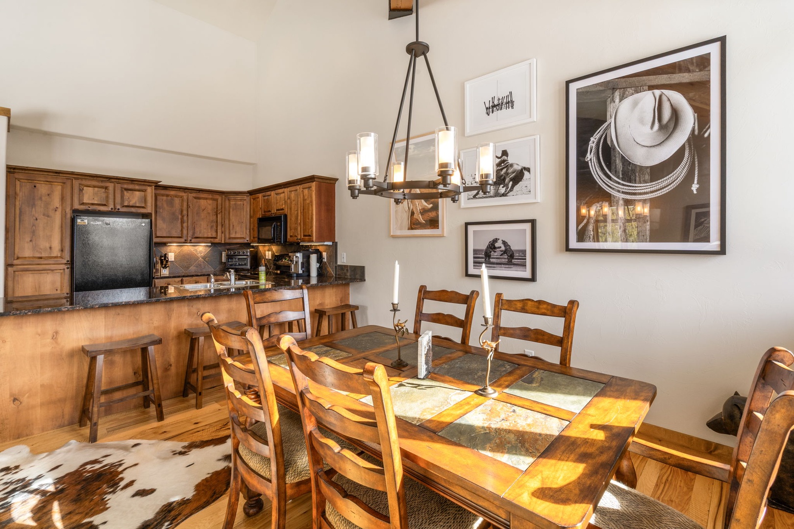 Gather around your rustic dining table where warm wood tones and Western artwork create the perfect setting for memorable meals together.